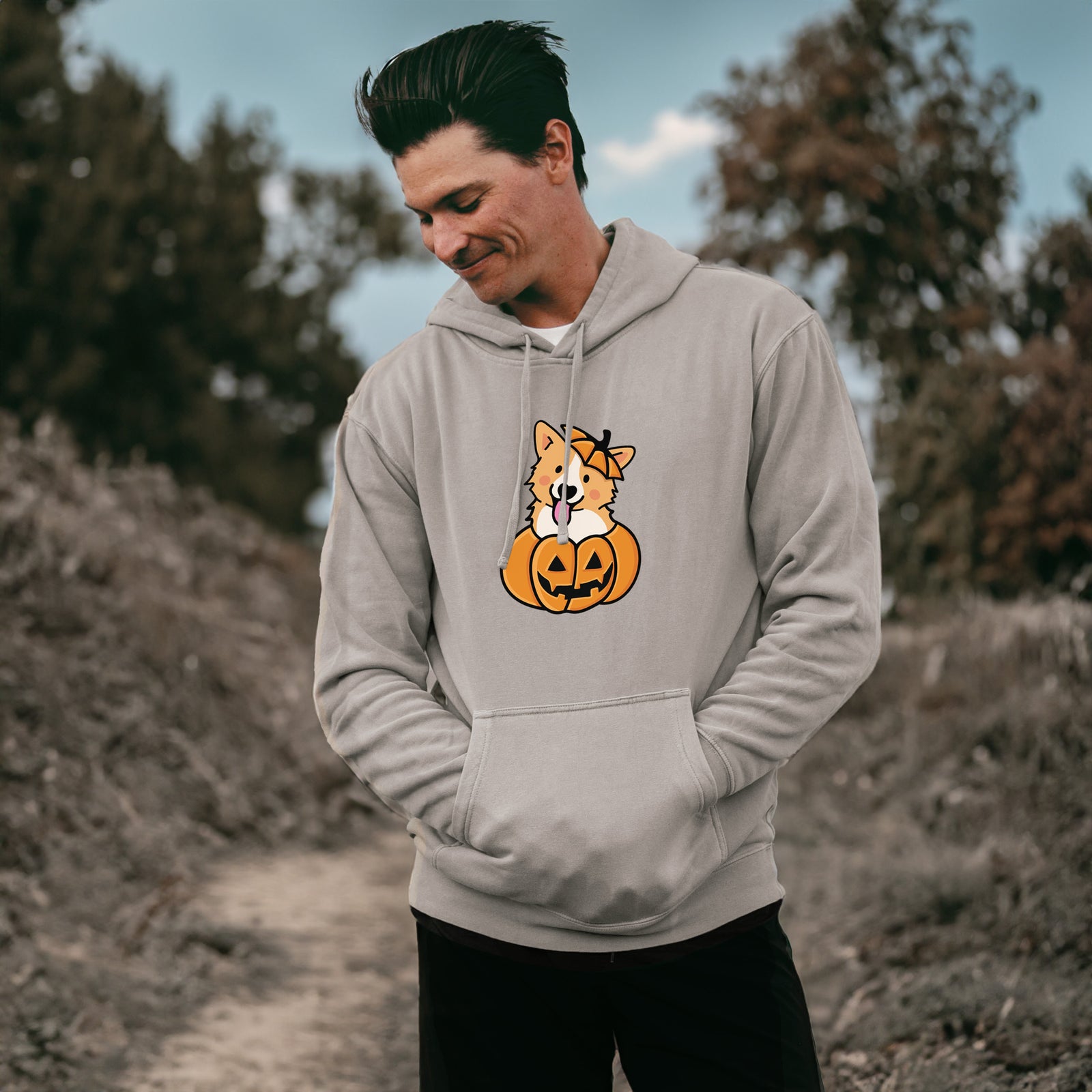 'Pumpkin Pup - Corgi' design on a Cement Unisex pigment dyed hoodie, worn by a man