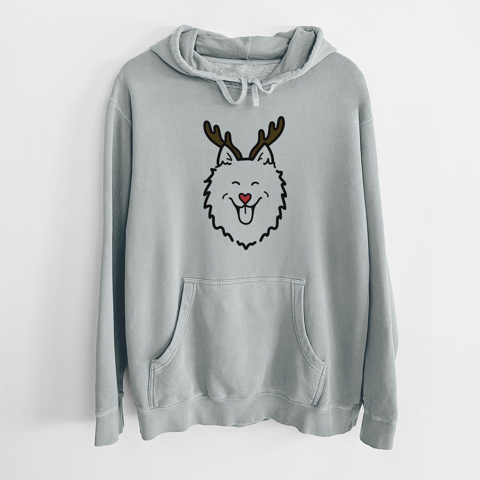 Minimalist line drawing of an American Eskimo with reindeer antlers and a red nose on a Sage Unisex pigment dyed hoodie