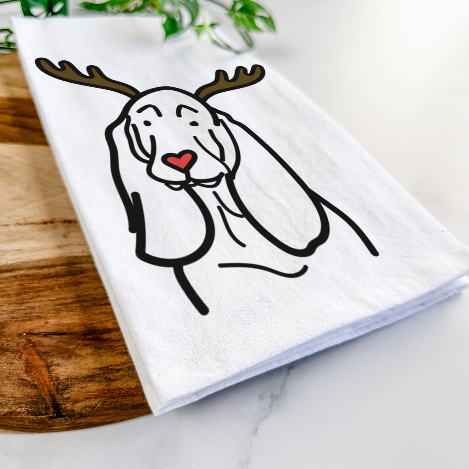 Minimalist line drawing of a Basset Hound with reindeer antlers and a red nose on a tea towel