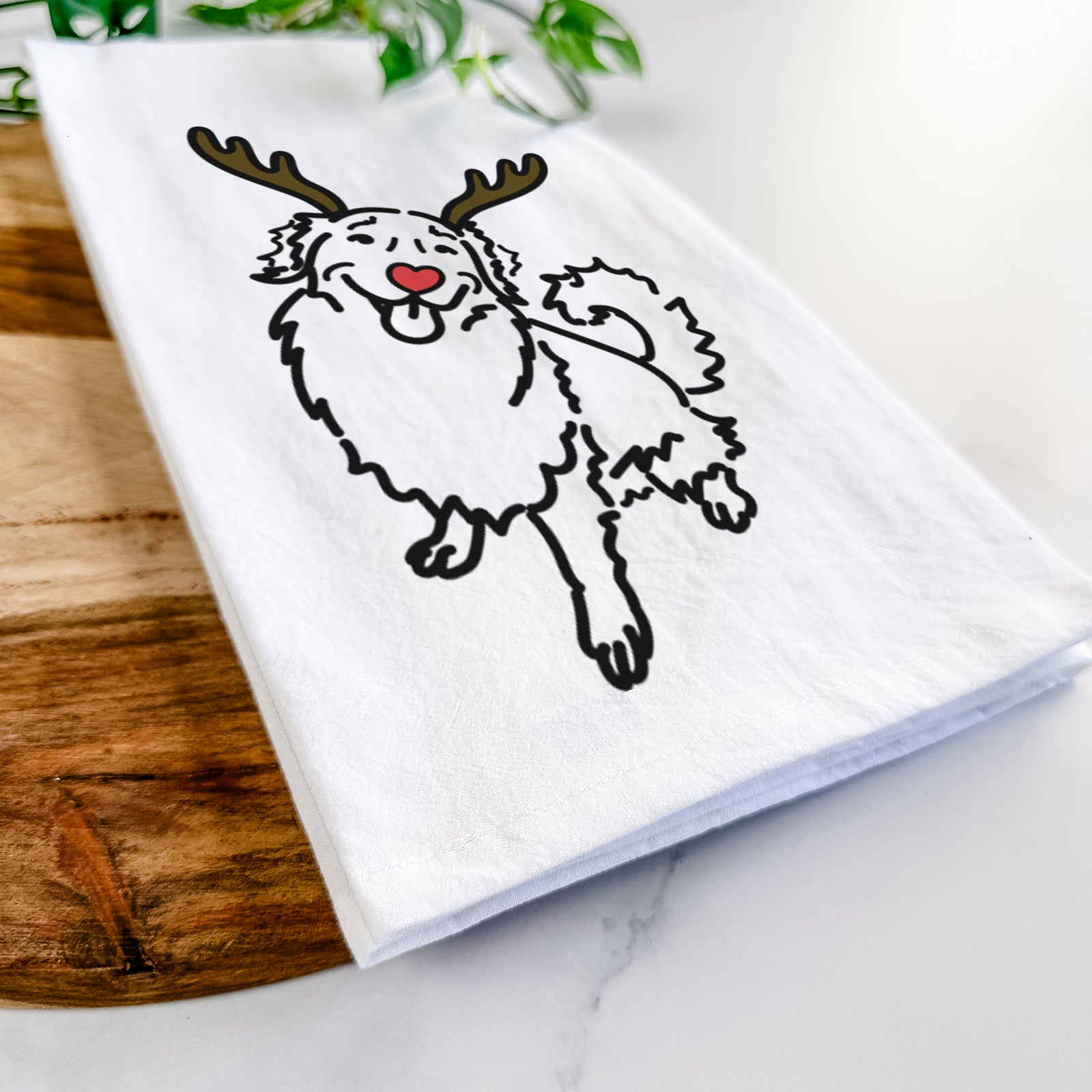 Minimalist line drawing of Brinkley the Golden Retriever with reindeer antlers and a red nose on a tea towel