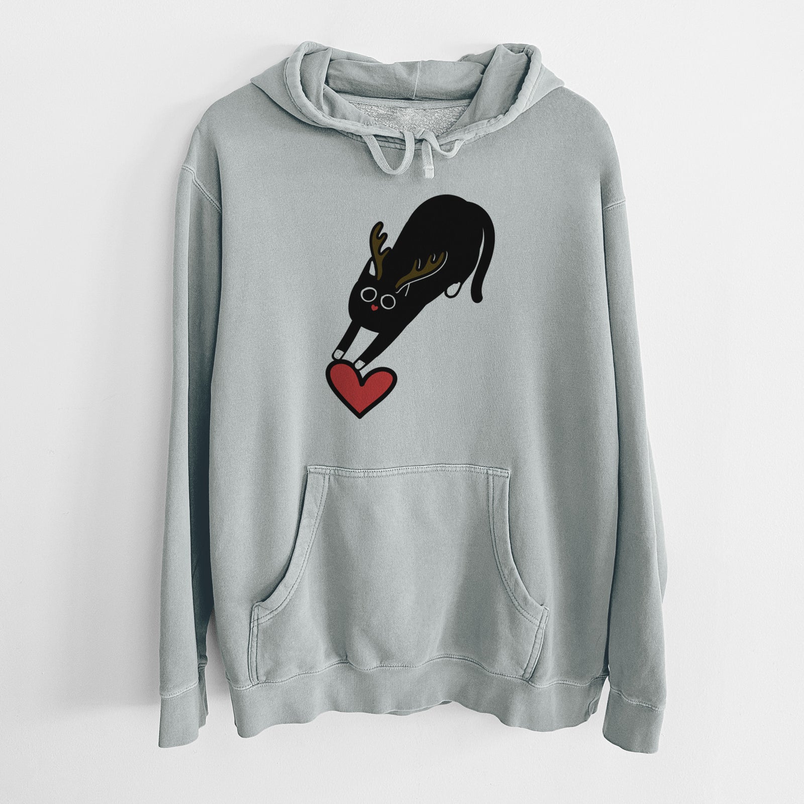 Minimalist line drawing of Bug the Black Cat with reindeer antlers and a red nose on a Sage Unisex pigment dyed hoodie