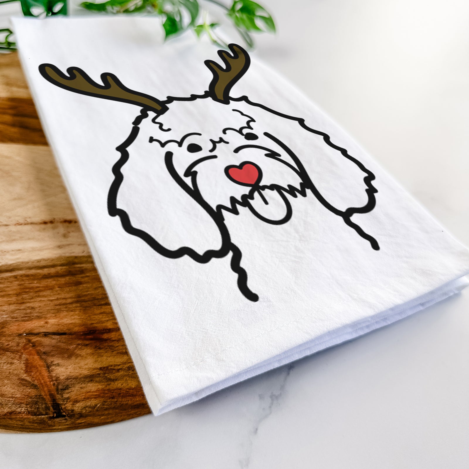 Minimalist line drawing of a Cockapoo with reindeer antlers and a red nose on a tea towel
