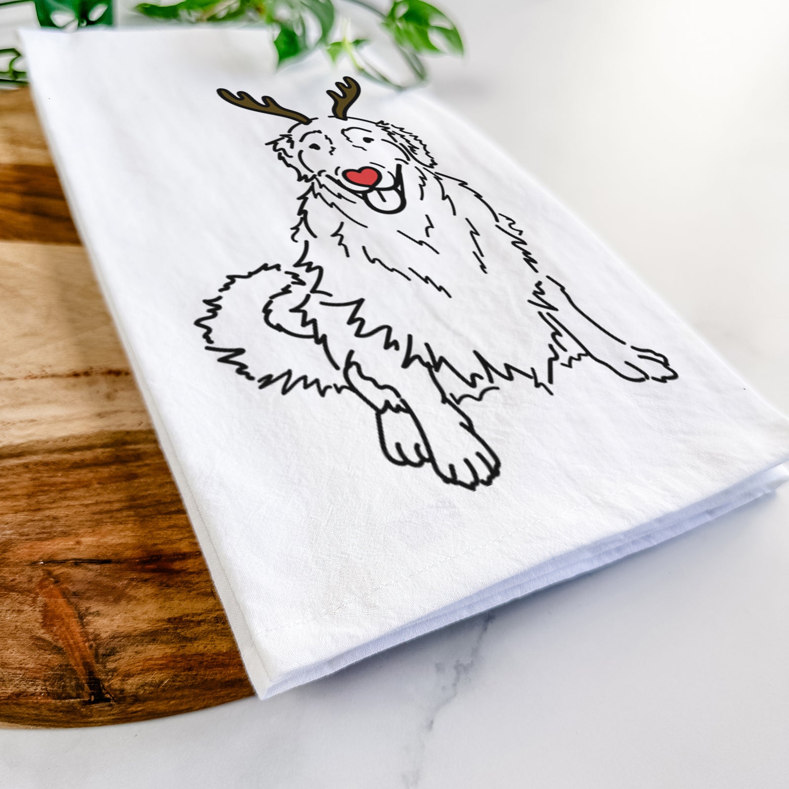 Minimalist line drawing of Daisy the Golden Retriever with reindeer antlers and a red nose on a tea towel