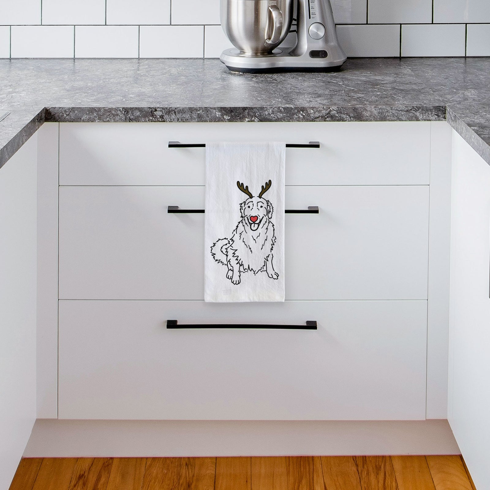 Minimalist line drawing of Daisy the Golden Retriever with reindeer antlers and a red nose on a tea towel, hanging on an oven door in a kitchen