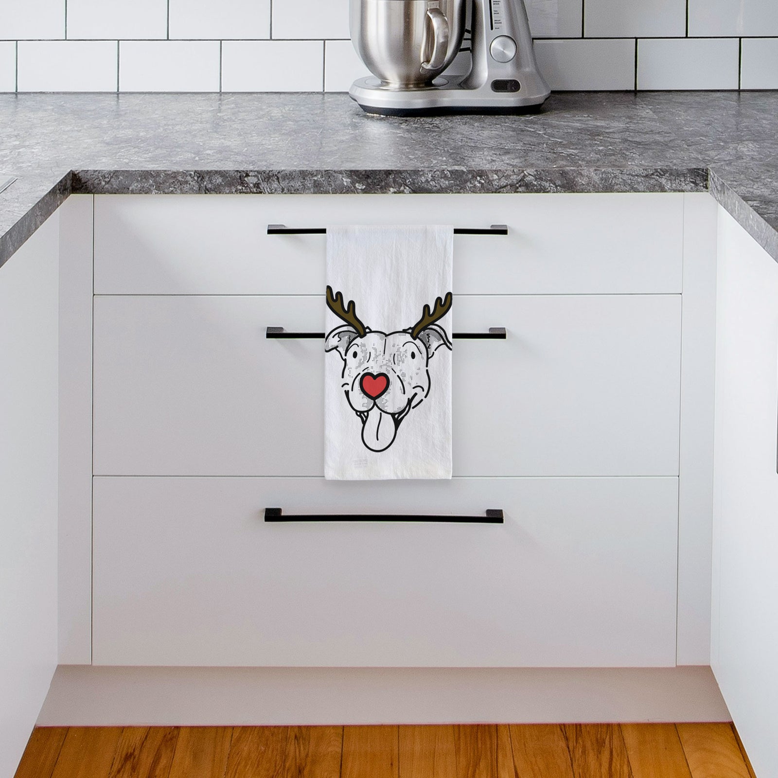 Minimalist line drawing of Dottie the Pitbull Mix with reindeer antlers and a red nose on a tea towel, hanging on an oven door in a kitchen