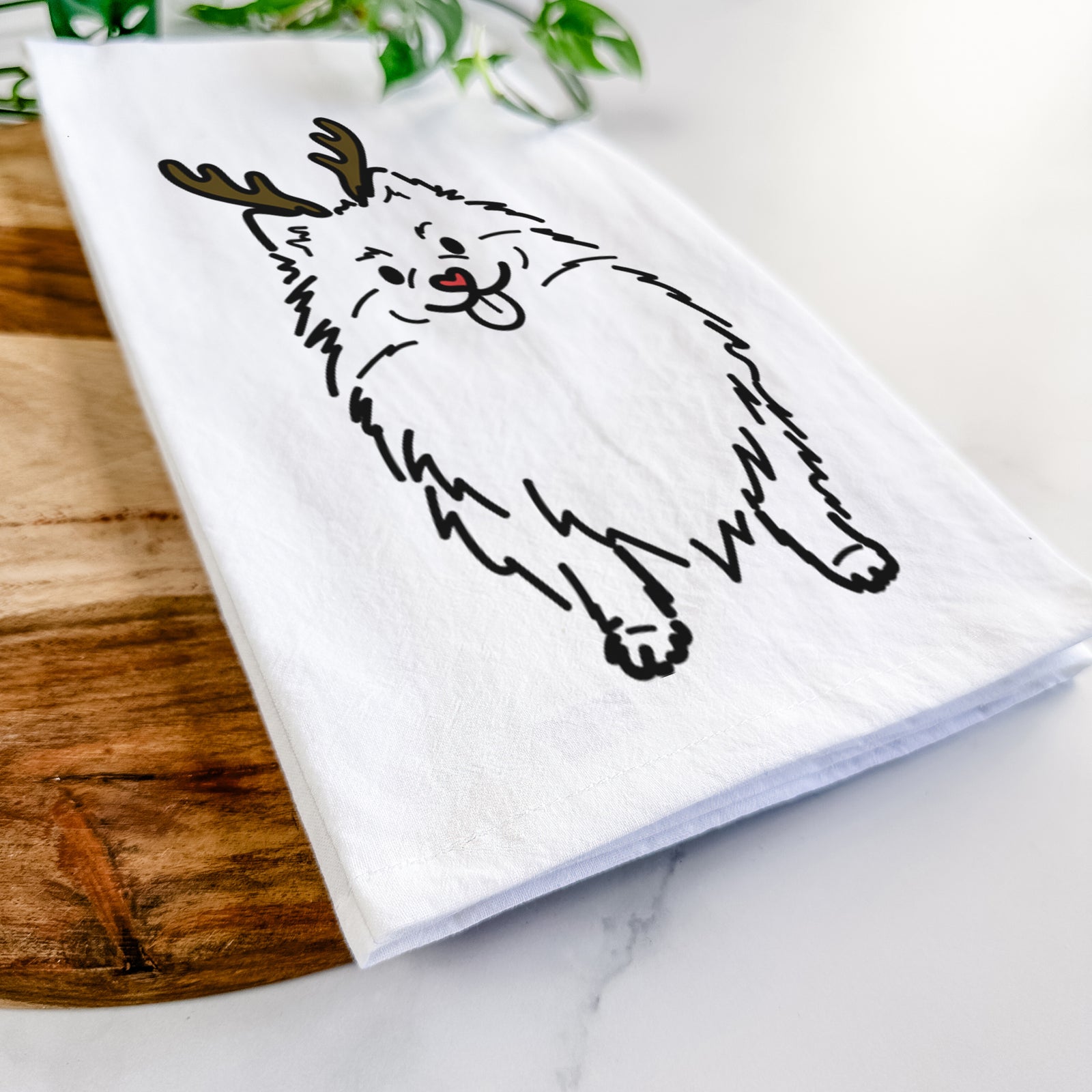 Minimalist line drawing of Fern the Pomeranian with reindeer antlers and a red nose on a tea towel