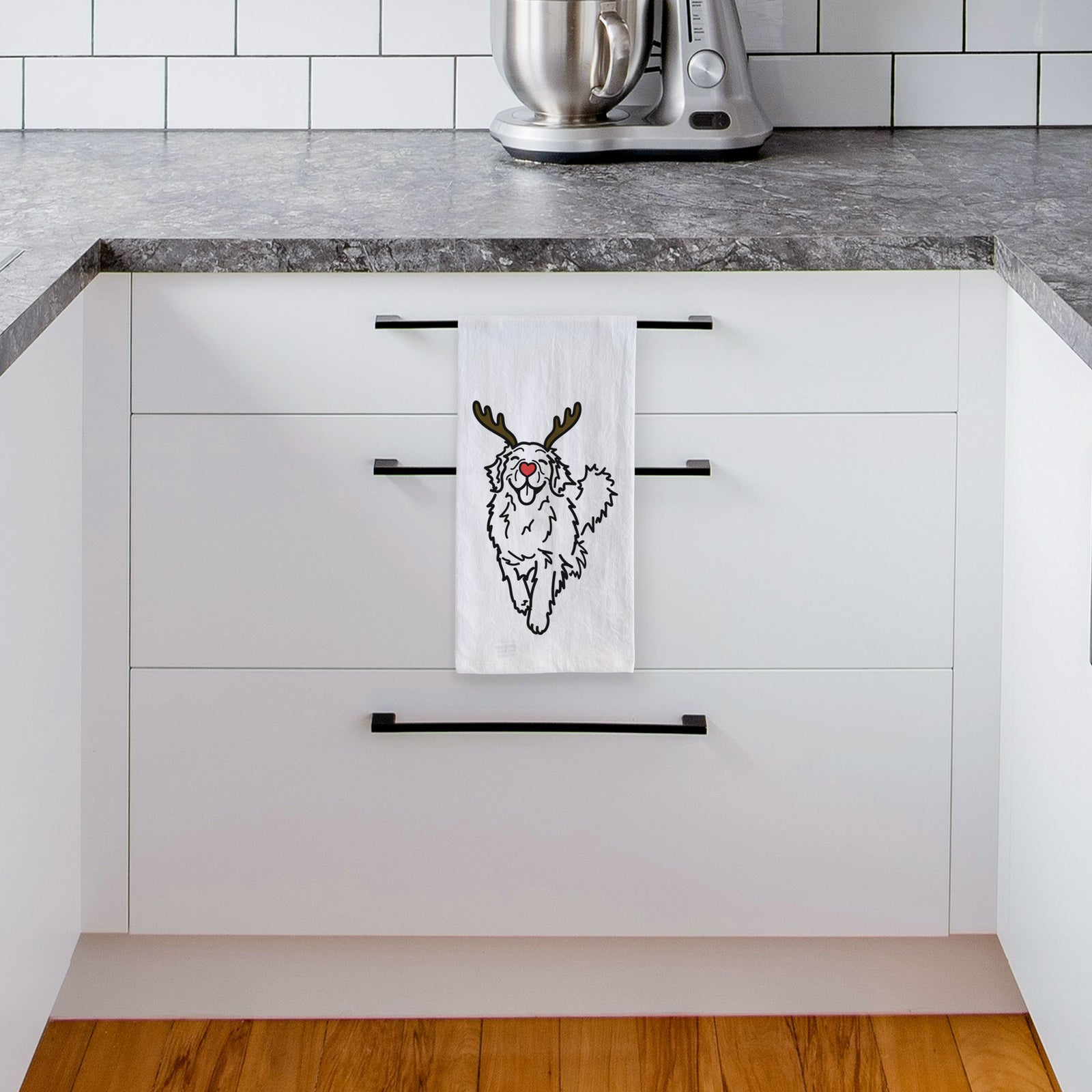 Minimalist line drawing of Hamlet the Golden Retriever with reindeer antlers and a red nose on a tea towel, hanging on an oven door in a kitchen