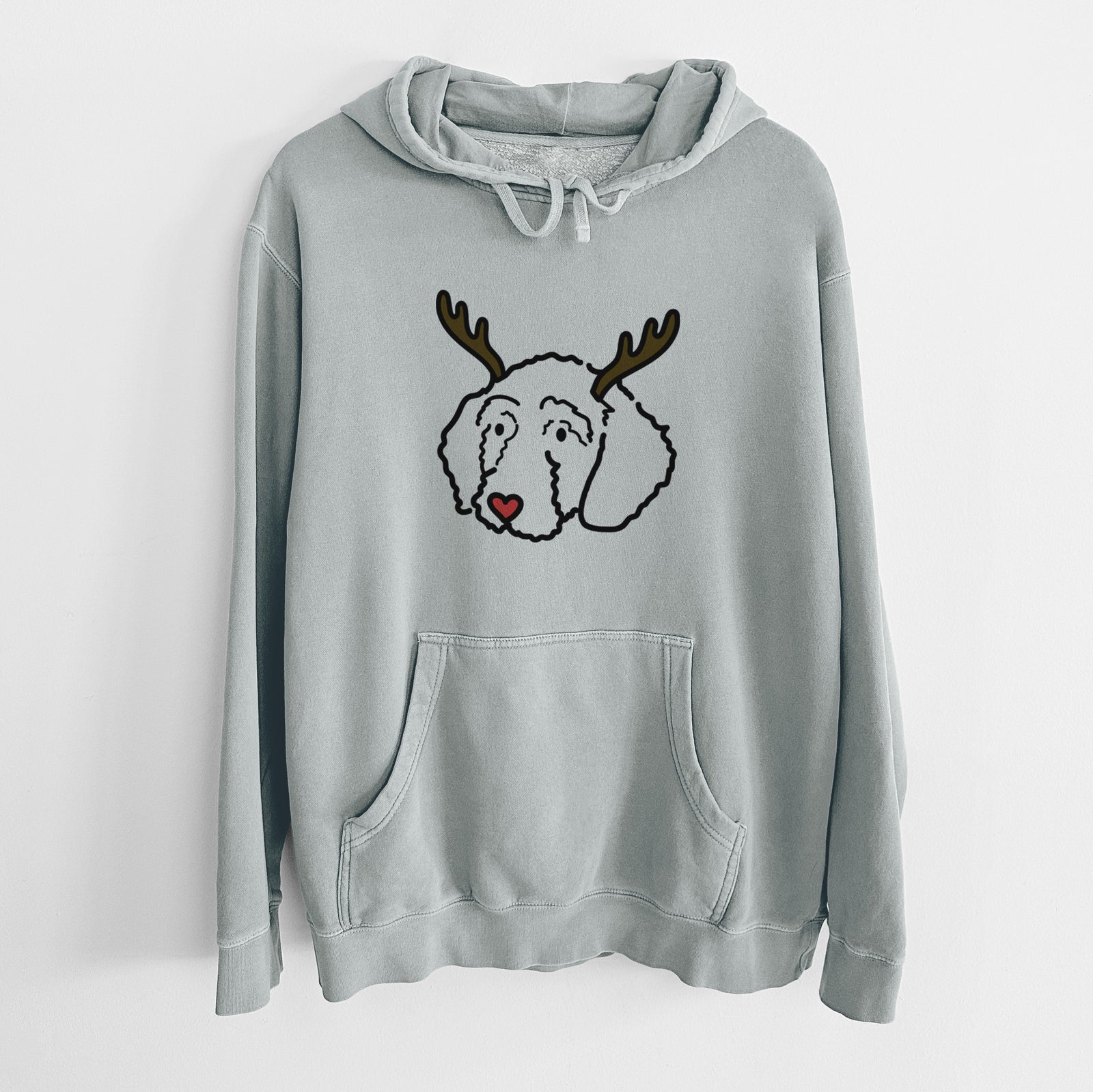 Minimalist line drawing of Hanna the Goldendoodle with reindeer antlers and a red nose on a Sage Unisex pigment dyed hoodie