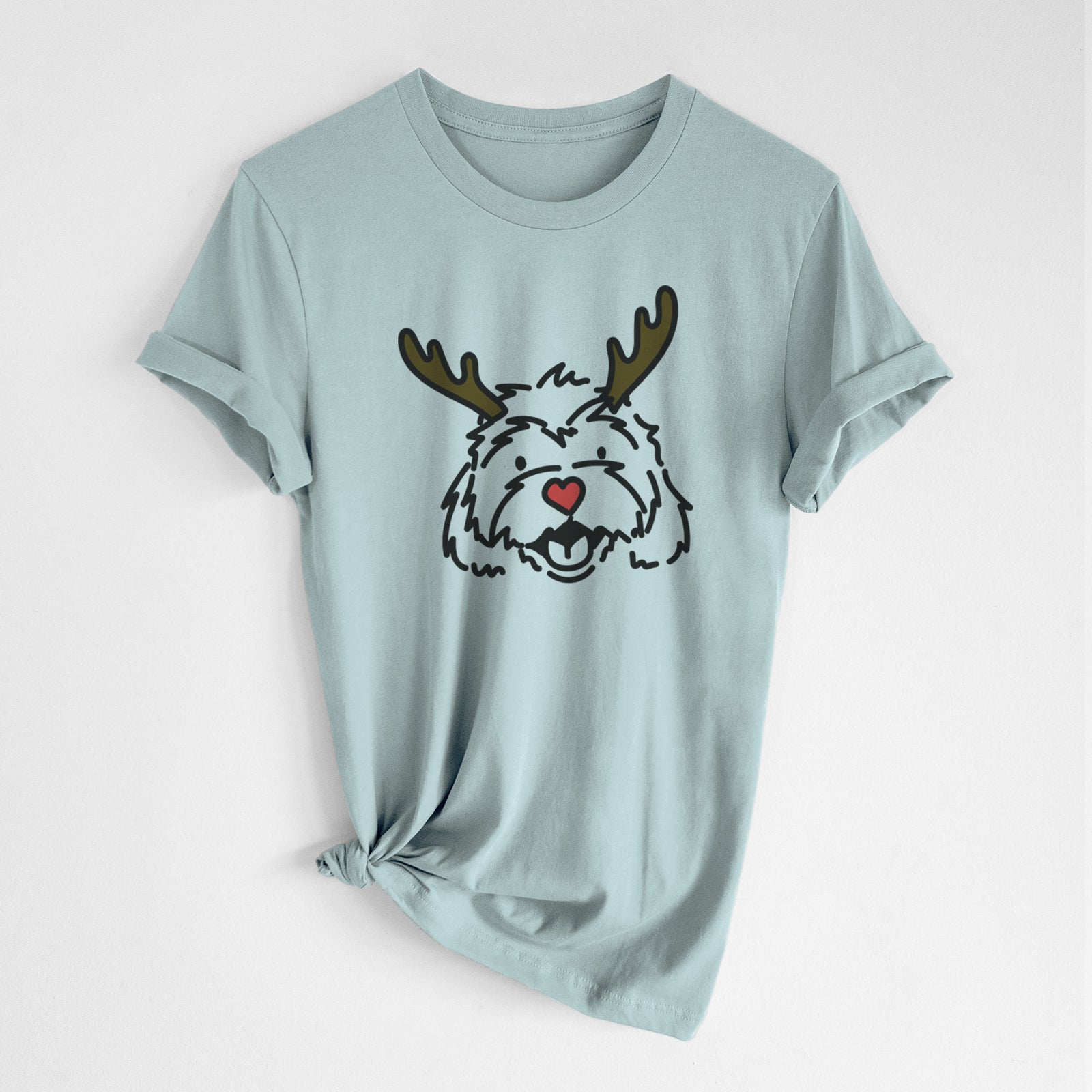 Minimalist line drawing of Harry the Cavachon with reindeer antlers and a red nose on a Dusty Blue Unisex crewneck, worn by a woman