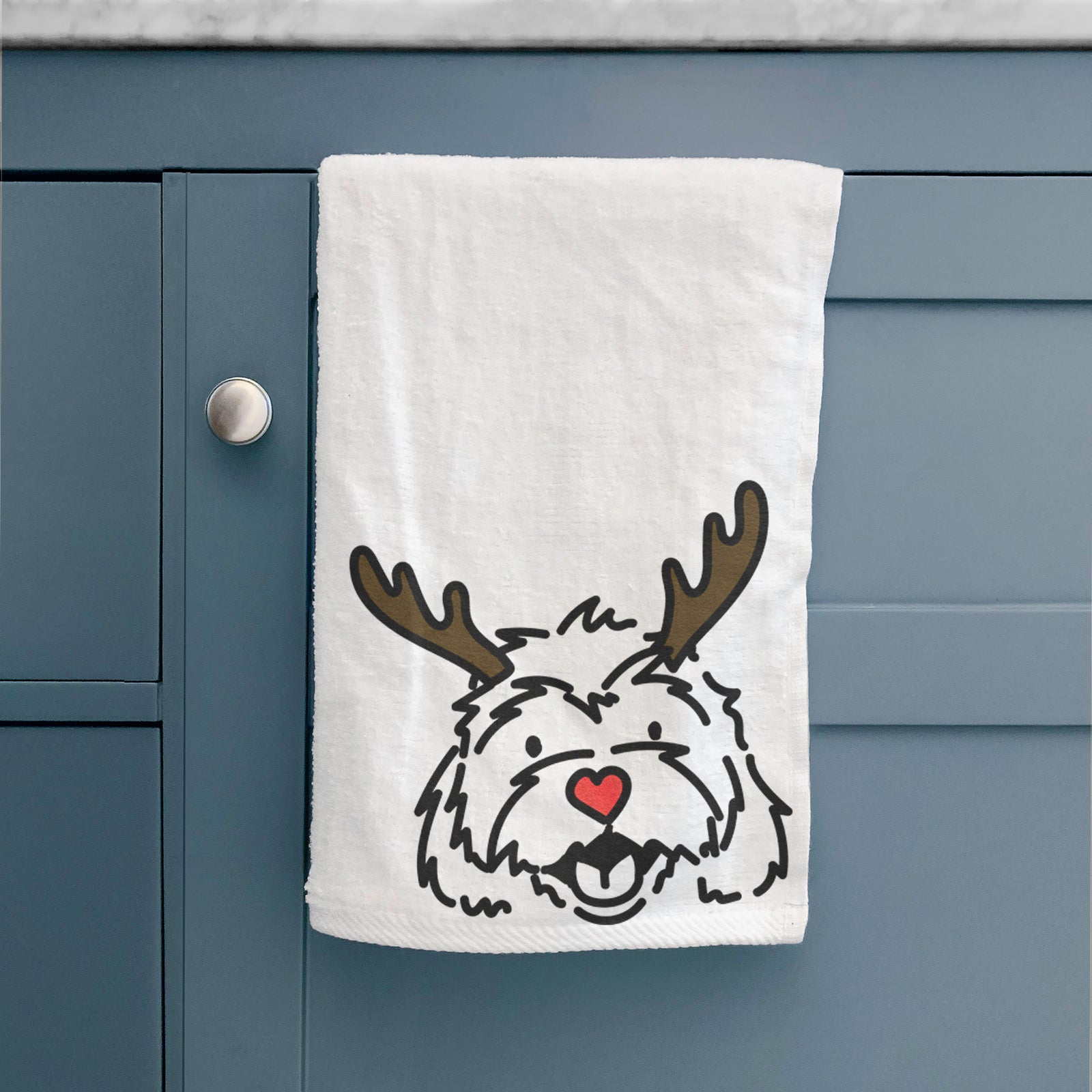 Minimalist line drawing of Harry the Cavachon with reindeer antlers and a red nose on a hand towel