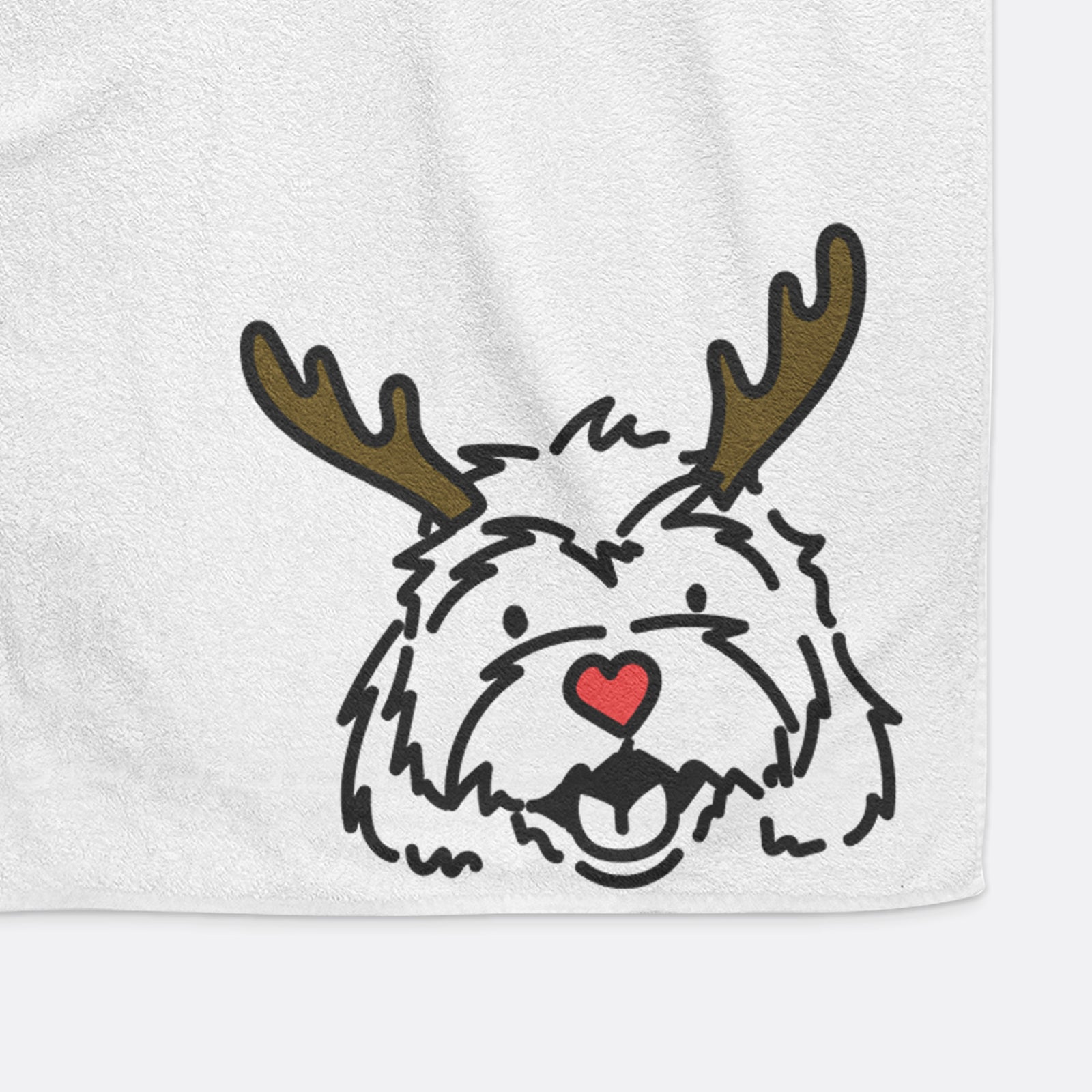 Minimalist line drawing of Harry the Cavachon with reindeer antlers and a red nose on a hand towel