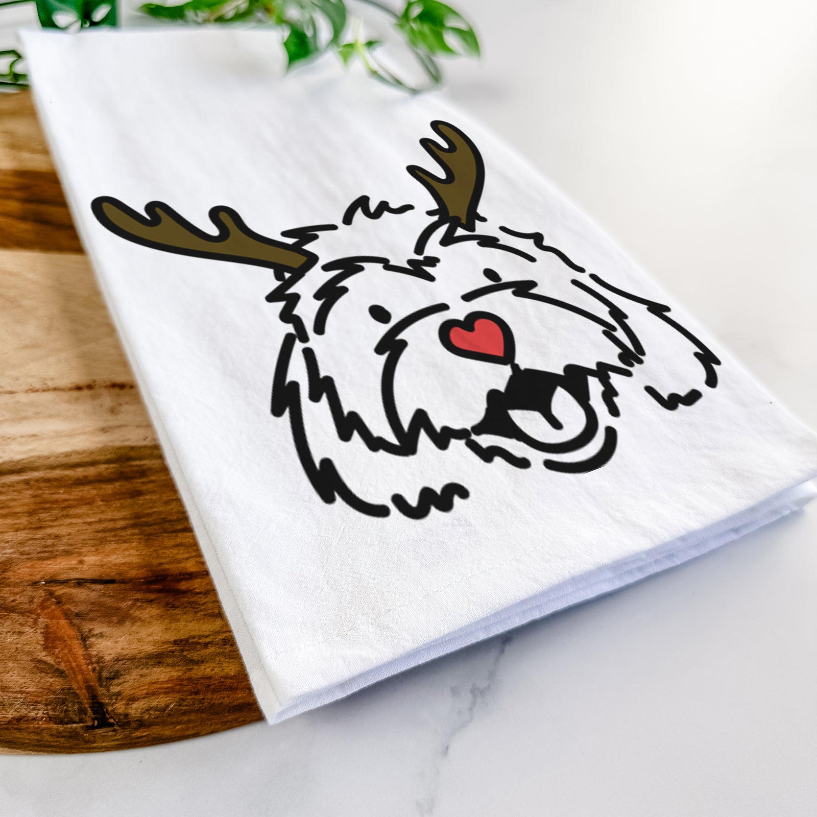 Minimalist line drawing of Harry the Cavachon with reindeer antlers and a red nose on a tea towel