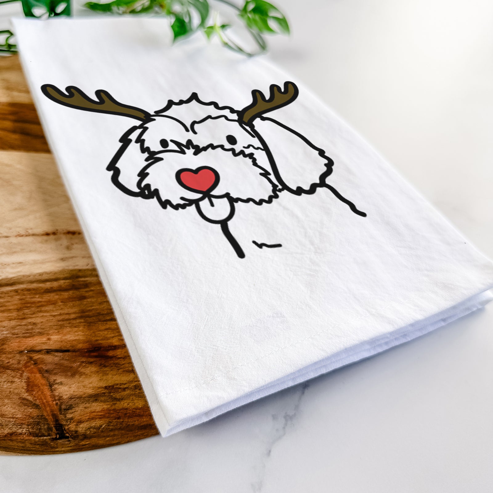 Minimalist line drawing of a Havapoo with reindeer antlers and a red nose on a tea towel