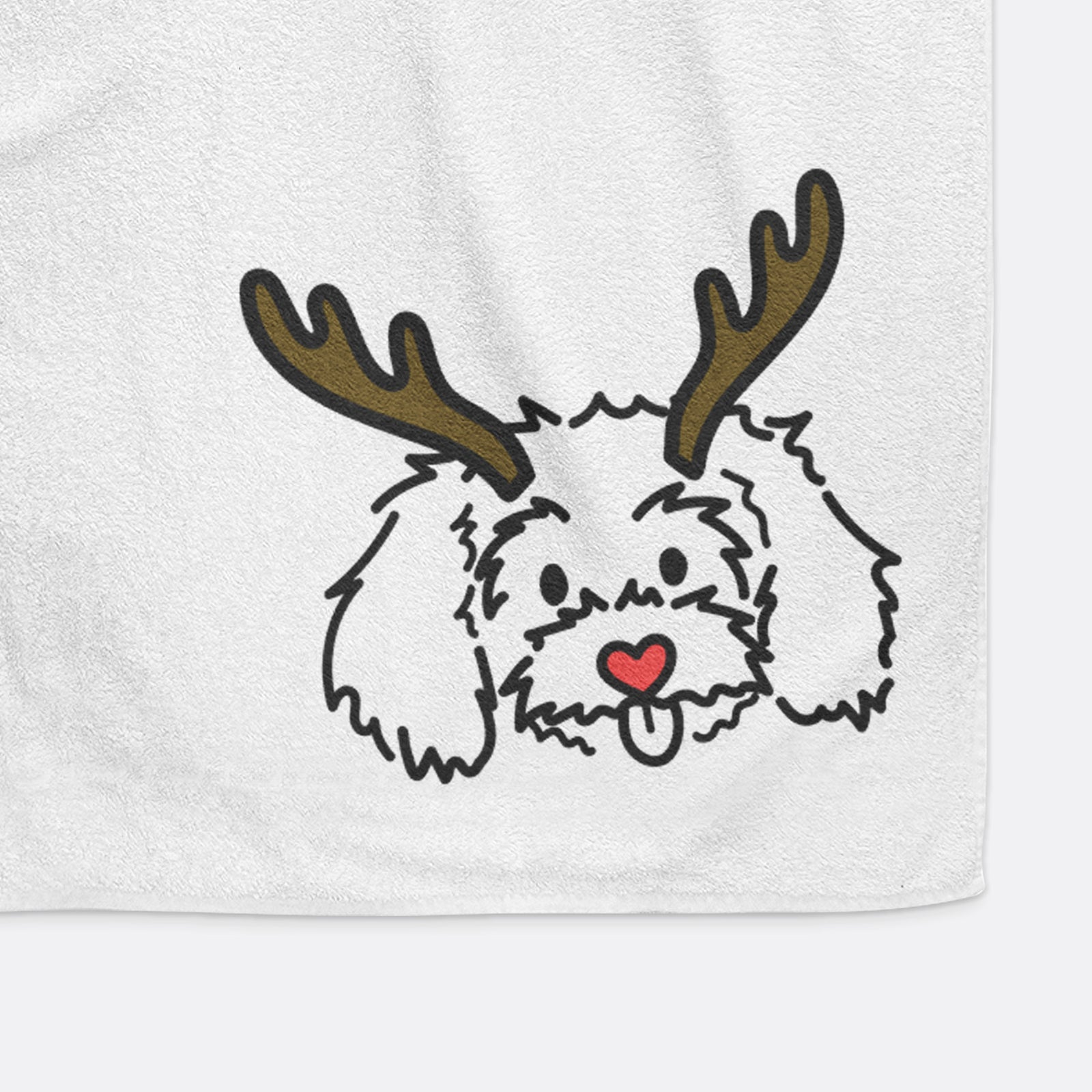 Minimalist line drawing of Holly the Maltipoo with reindeer antlers and a red nose on a decorative hand towel