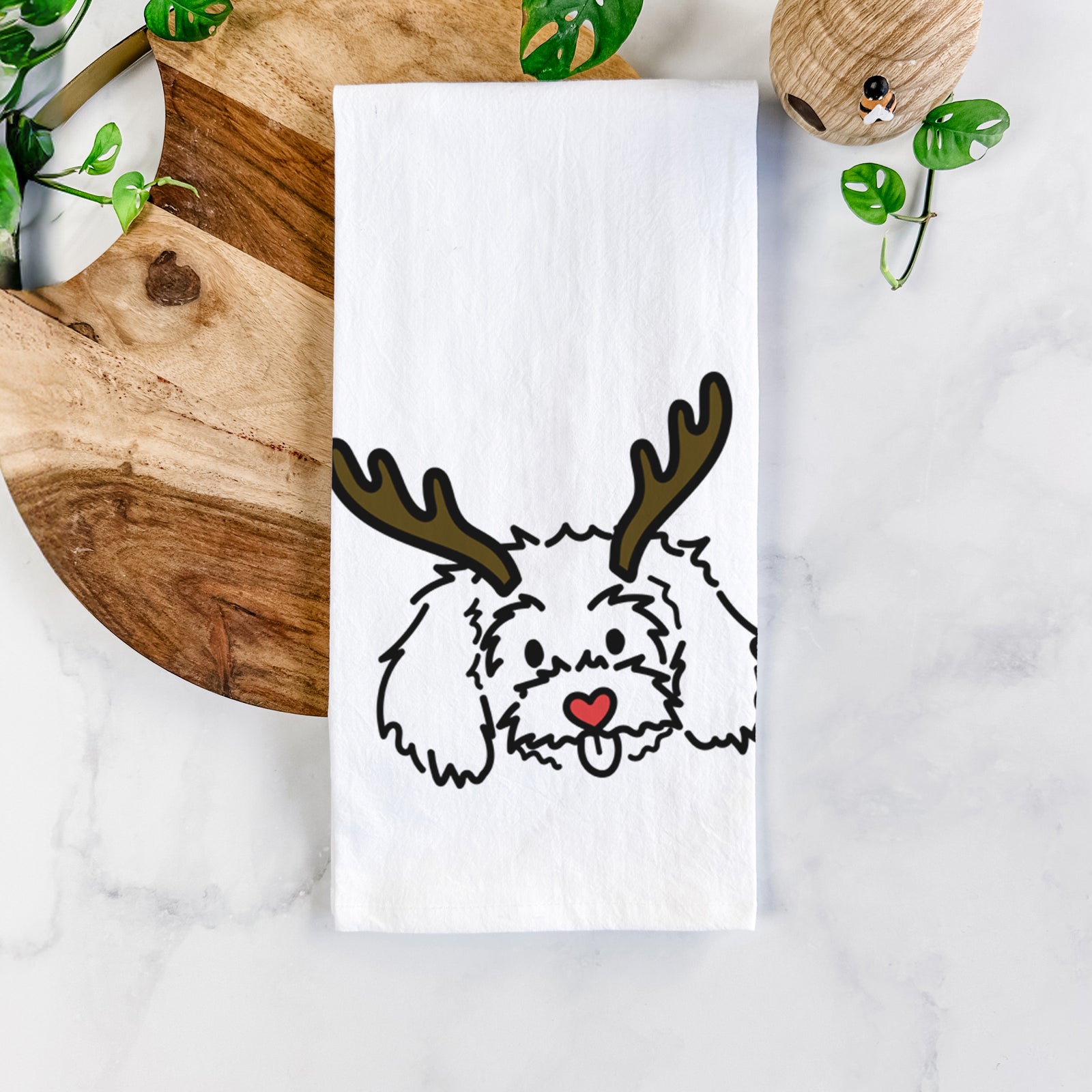 Minimalist line drawing of Holly the Maltipoo with reindeer antlers and a red nose on a tea towel