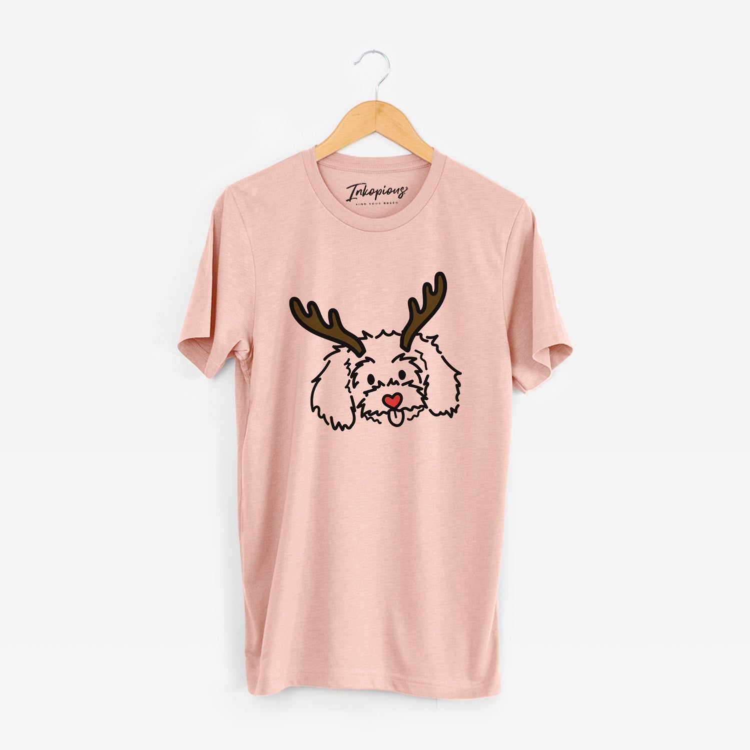Minimalist line drawing of Holly the Maltipoo with reindeer antlers and a red nose on a Peach Unisex crewneck