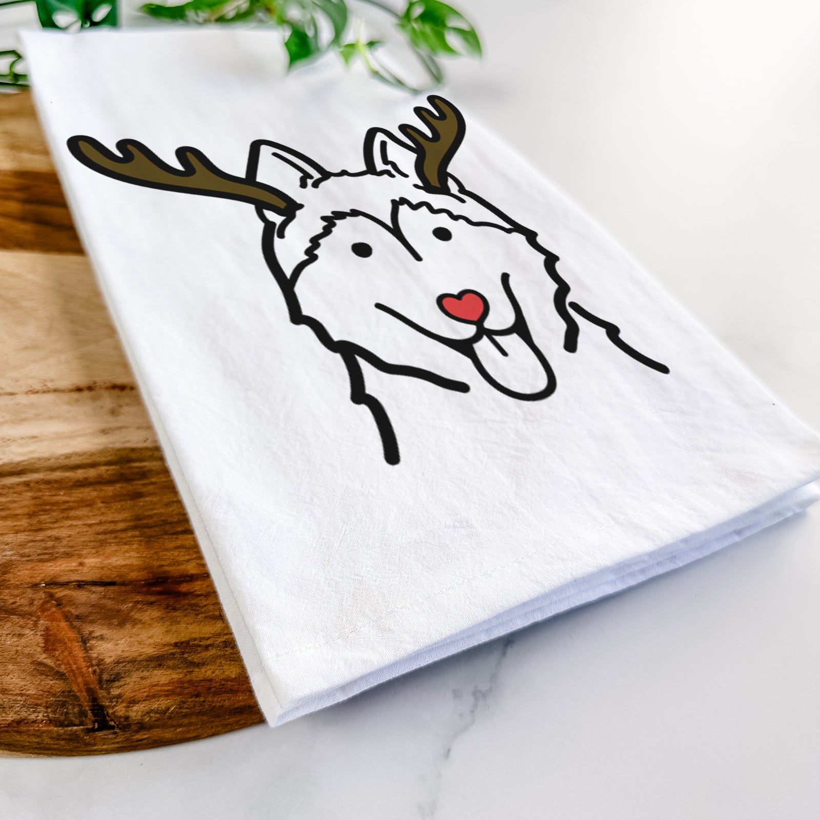 Minimalist line drawing of a Siberian Husky with reindeer antlers and a red nose on a tea towel