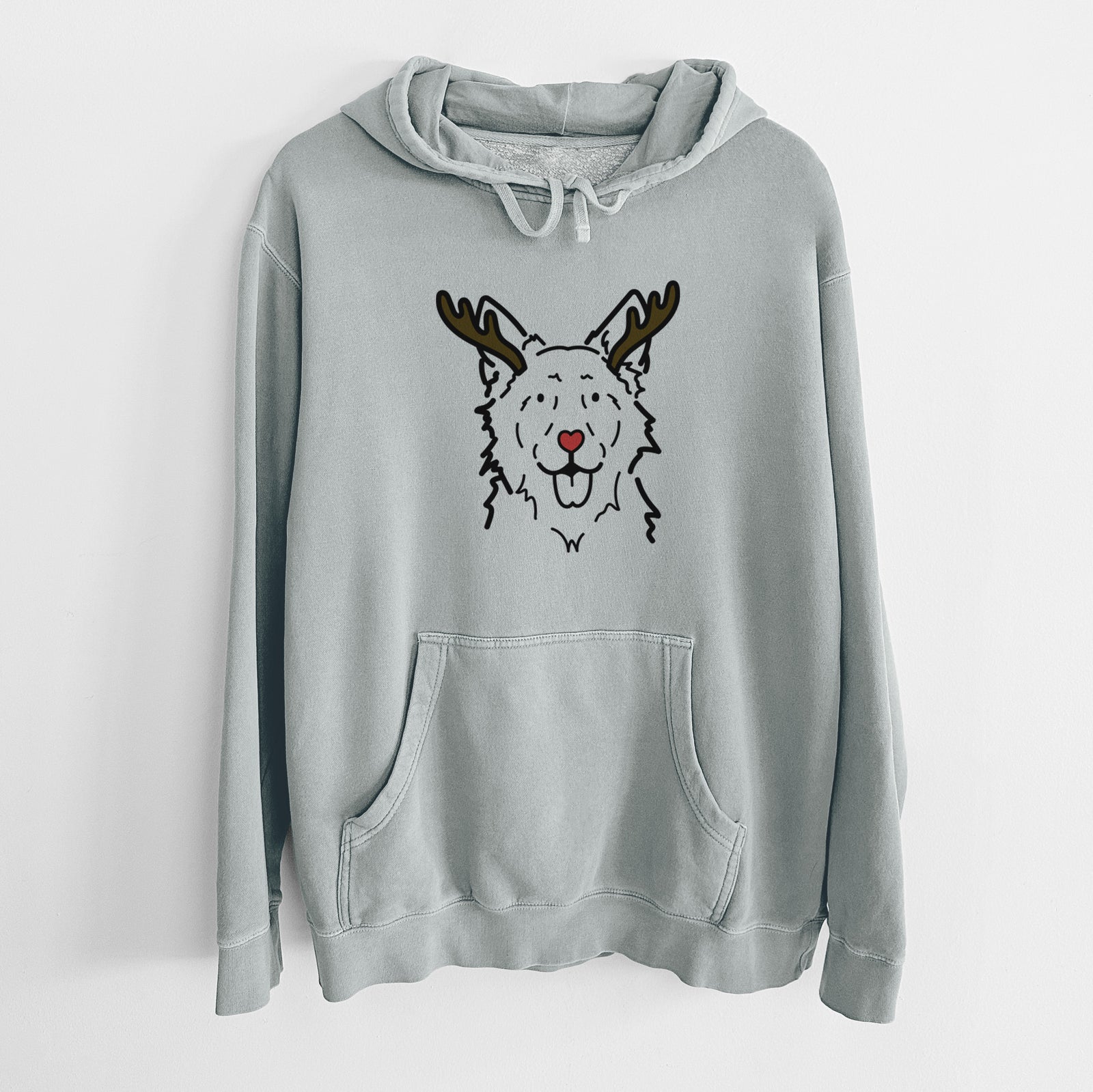 Minimalist line drawing of Jack the Mudi with reindeer antlers and a red nose on a Sage Unisex pigment dyed hoodie