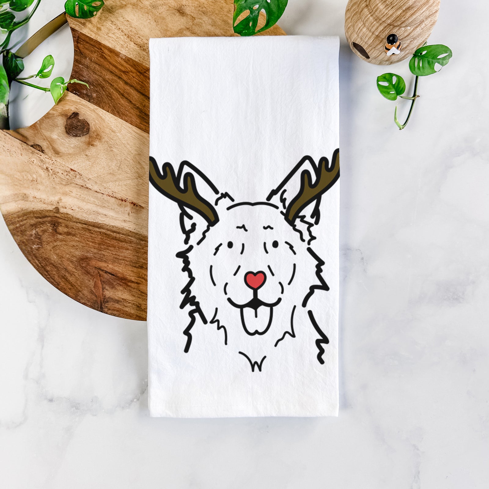 Minimalist line drawing of Jack the Mudi with reindeer antlers and a red nose on a tea towel