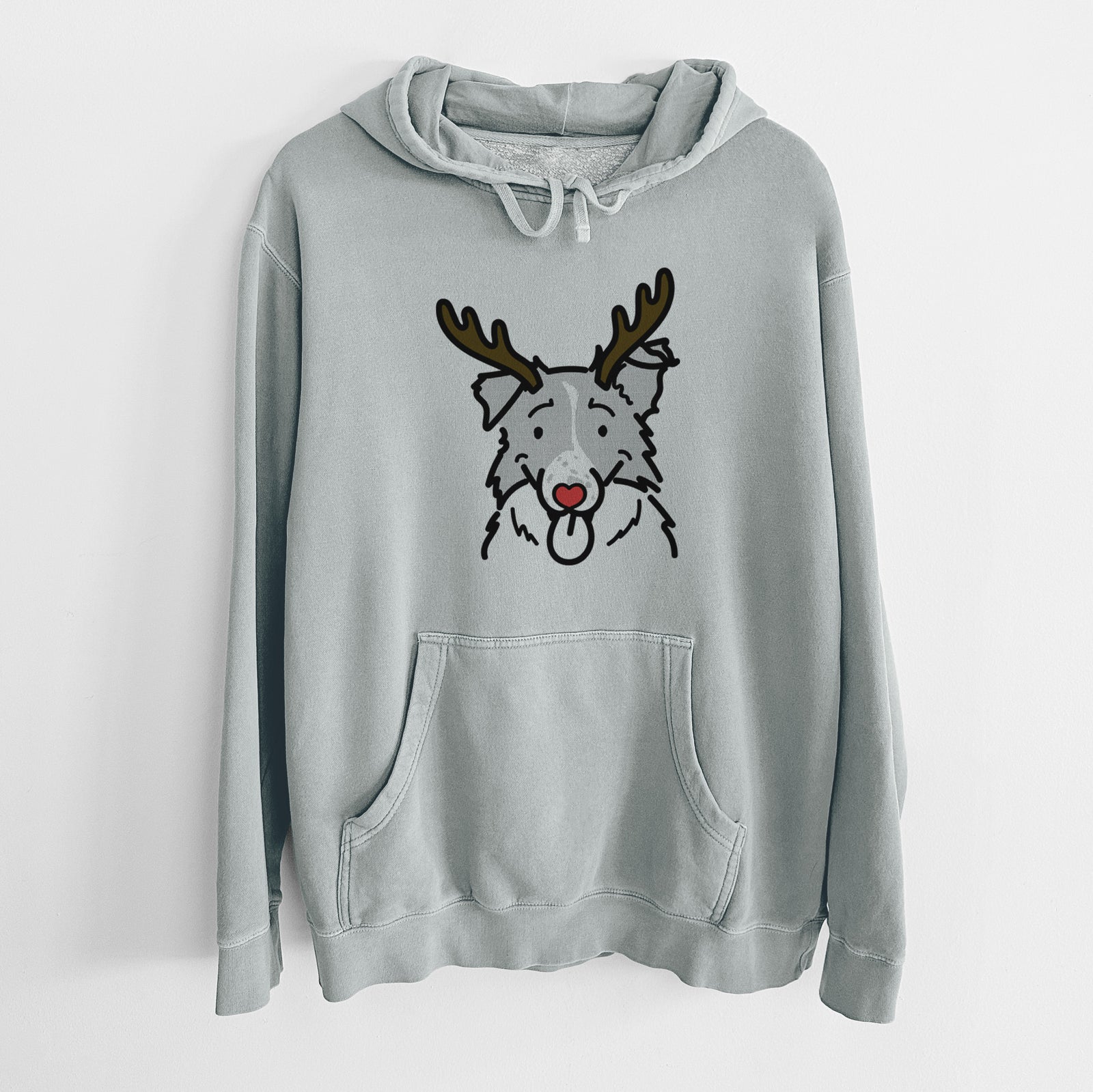 Minimalist line drawing of Jam the Border Collie with reindeer antlers and a red nose on a Sage Unisex pigment dyed hoodie