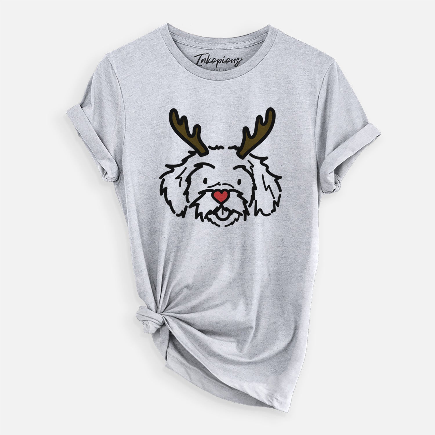 Minimalist line drawing of Jo Jo the Peekapoo with reindeer antlers and a red nose on a Grey Unisex crewneck, worn by a woman