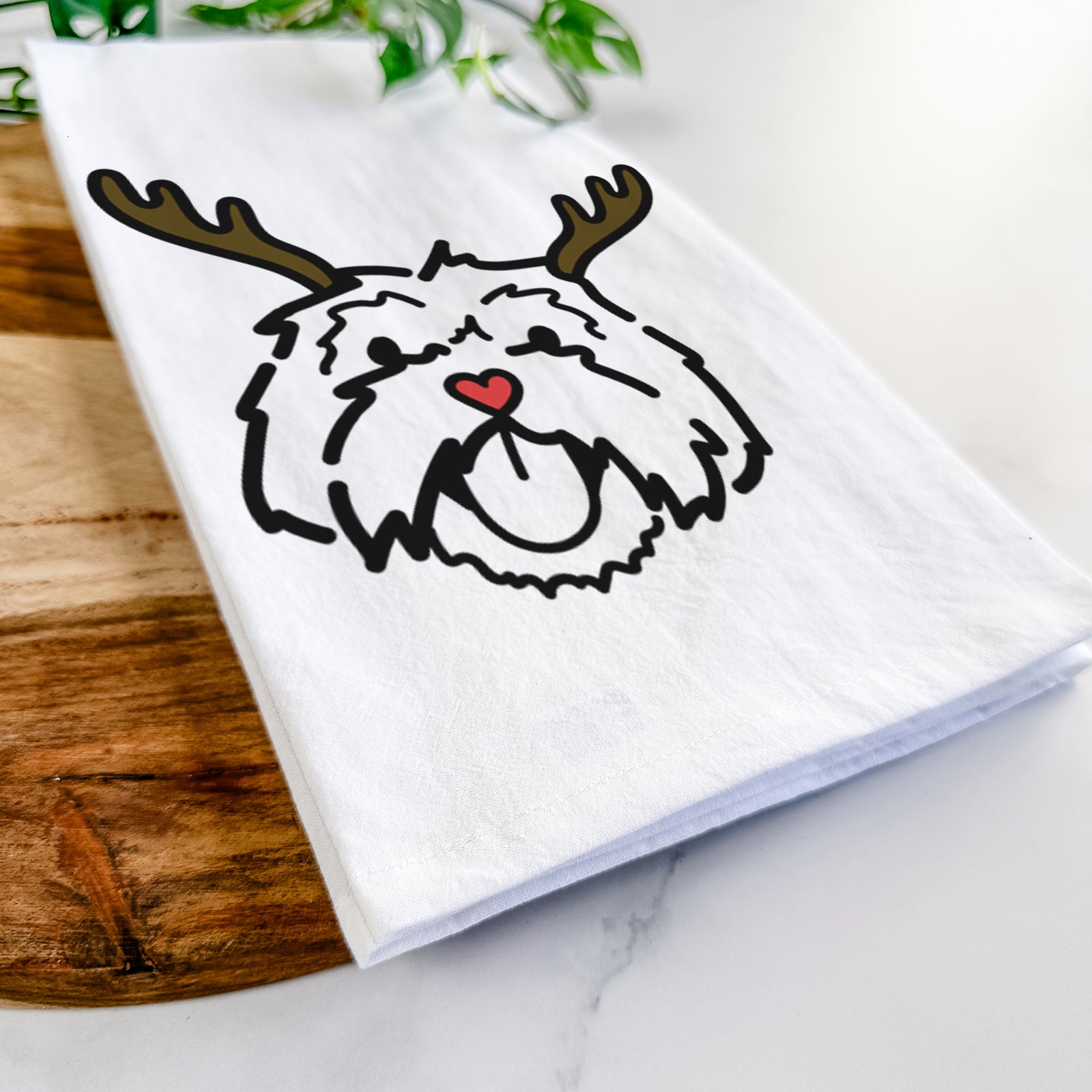 Minimalist line drawing of Keia the Lhasa Apso with reindeer antlers and a red nose on a tea towel