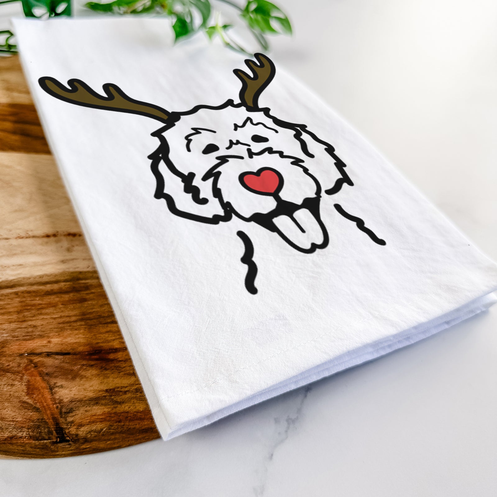 Minimalist line drawing of a Labradoodle with reindeer antlers and a red nose on a tea towel