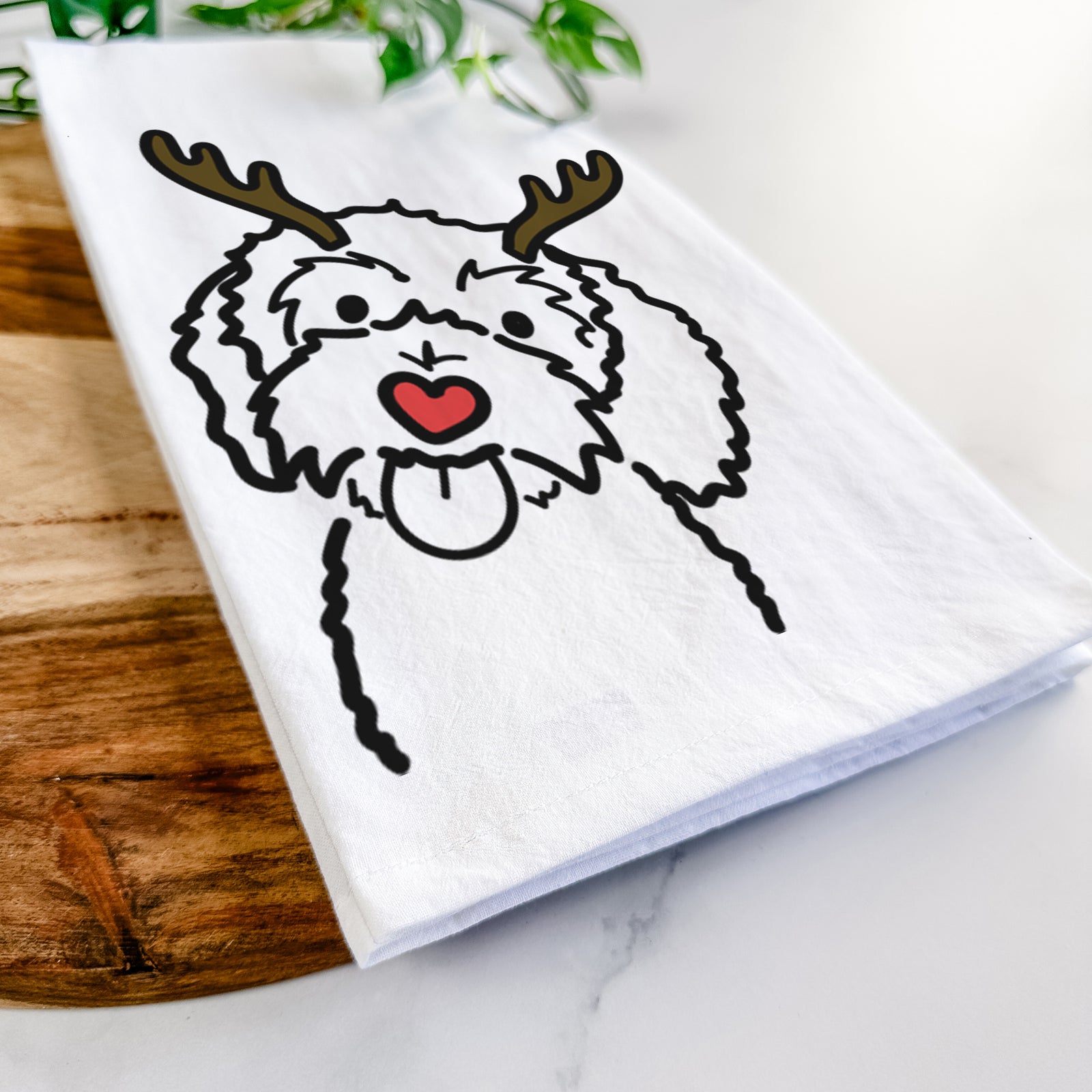 Minimalist line drawing of Mabel the Bernedoodle with reindeer antlers and a red nose on a tea towel