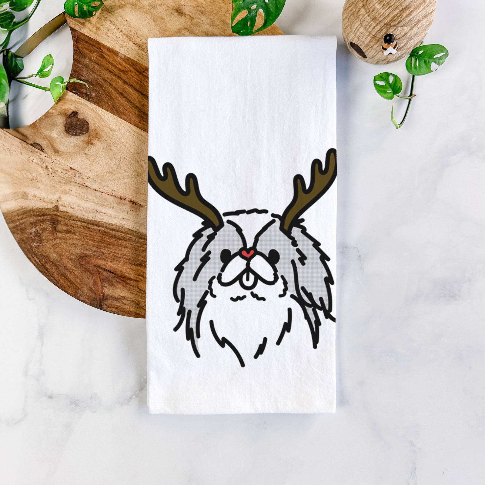 Minimalist line drawing of Macha the Japanese Chin with reindeer antlers and a red nose on a tea towel