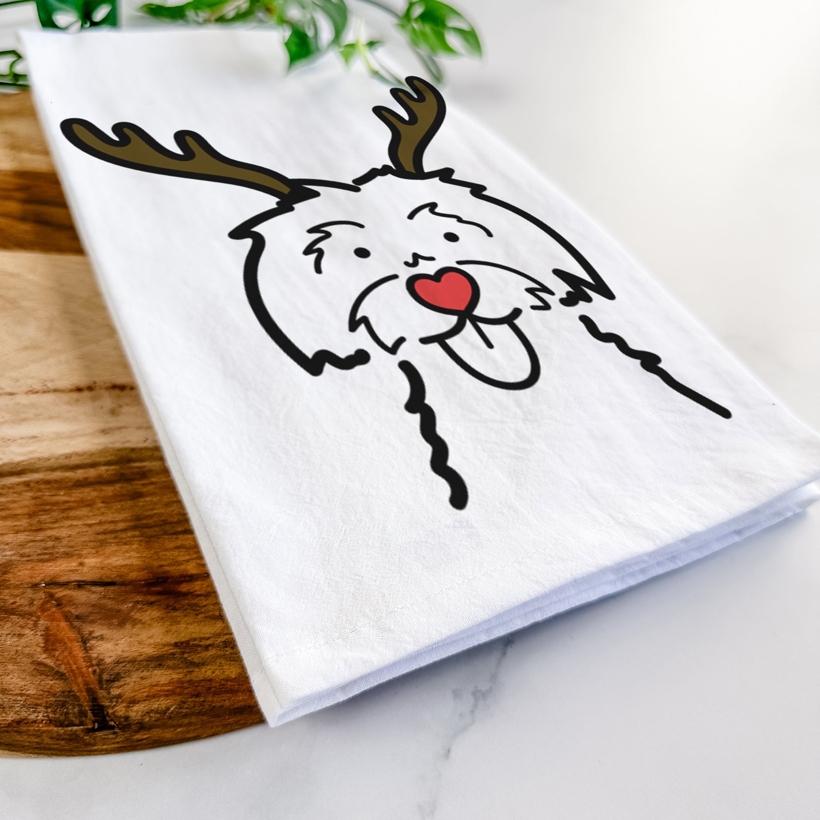 Minimalist line drawing of a Maltese with reindeer antlers and a red nose on a tea towel