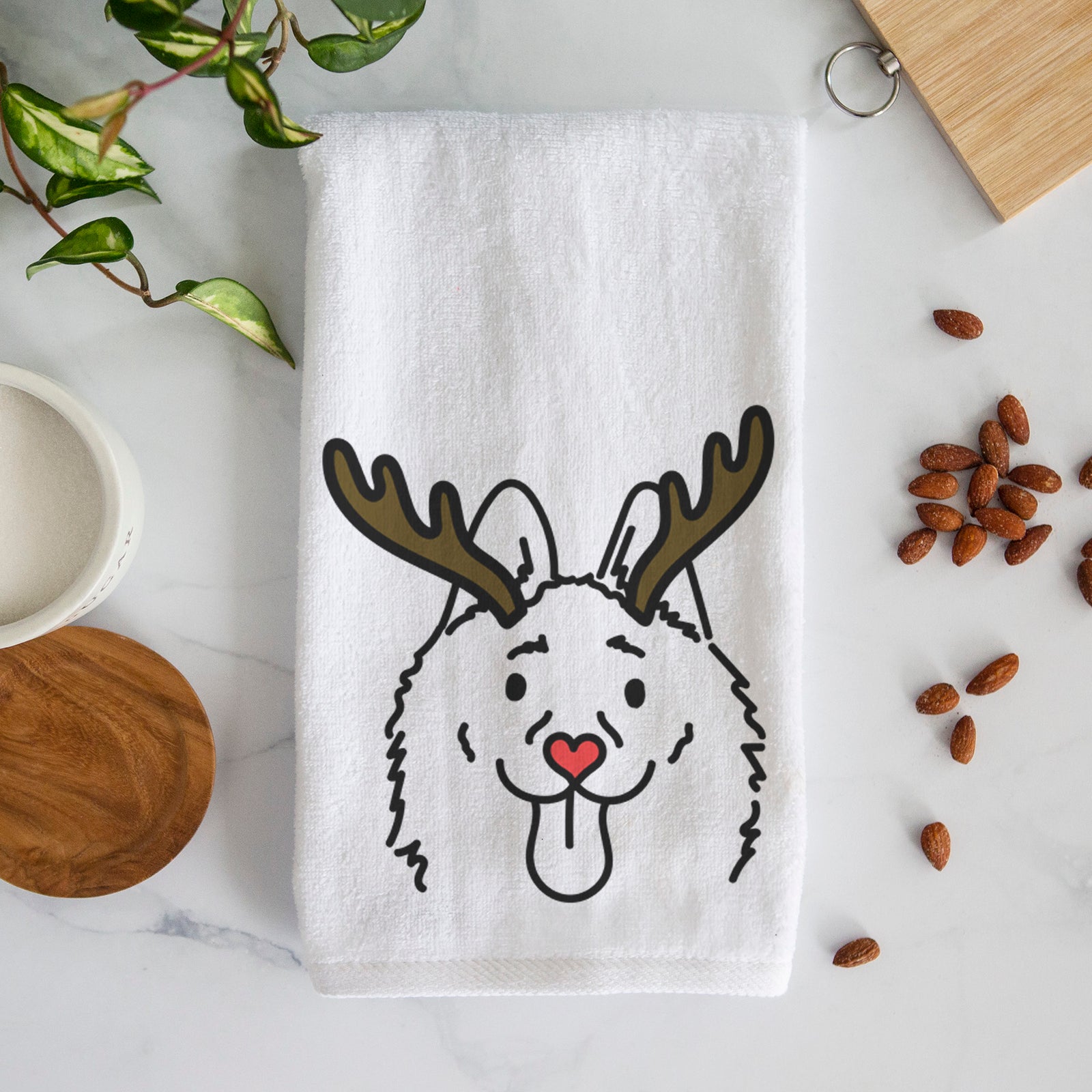 Minimalist line drawing of Meeko the Schipperke with reindeer antlers and a red nose on a decorative hand towel