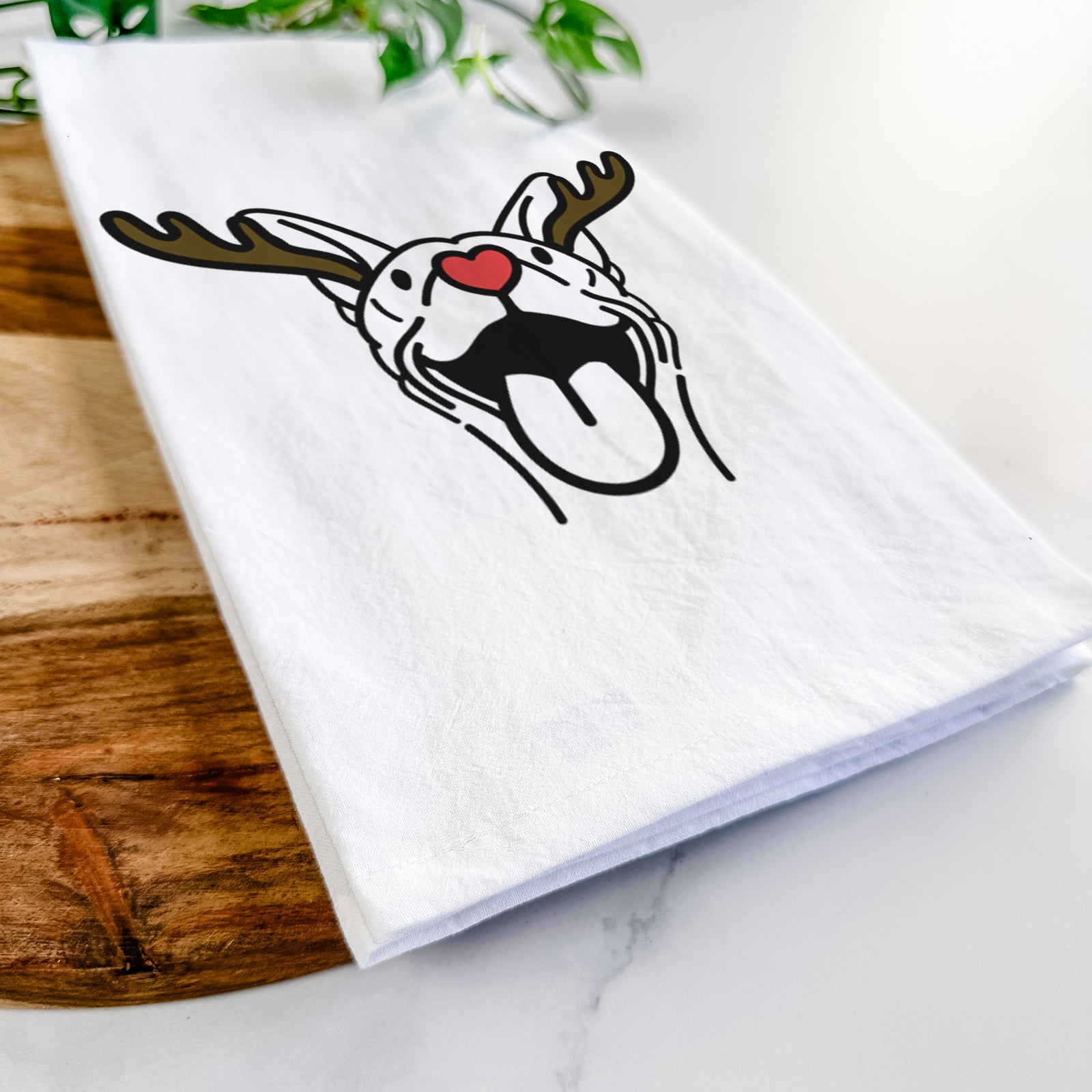 Minimalist line drawing of Merlin the Basenji with reindeer antlers and a red nose on a tea towel
