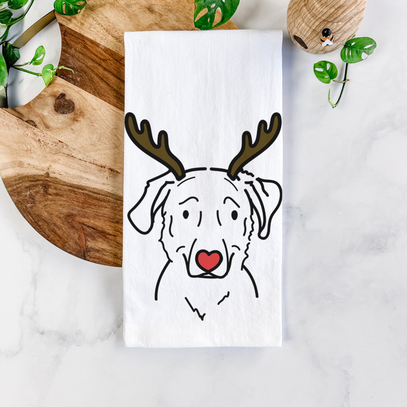 Minimalist line drawing of Mitzi the Golden Retriever Mix with reindeer antlers and a red nose on a tea towel