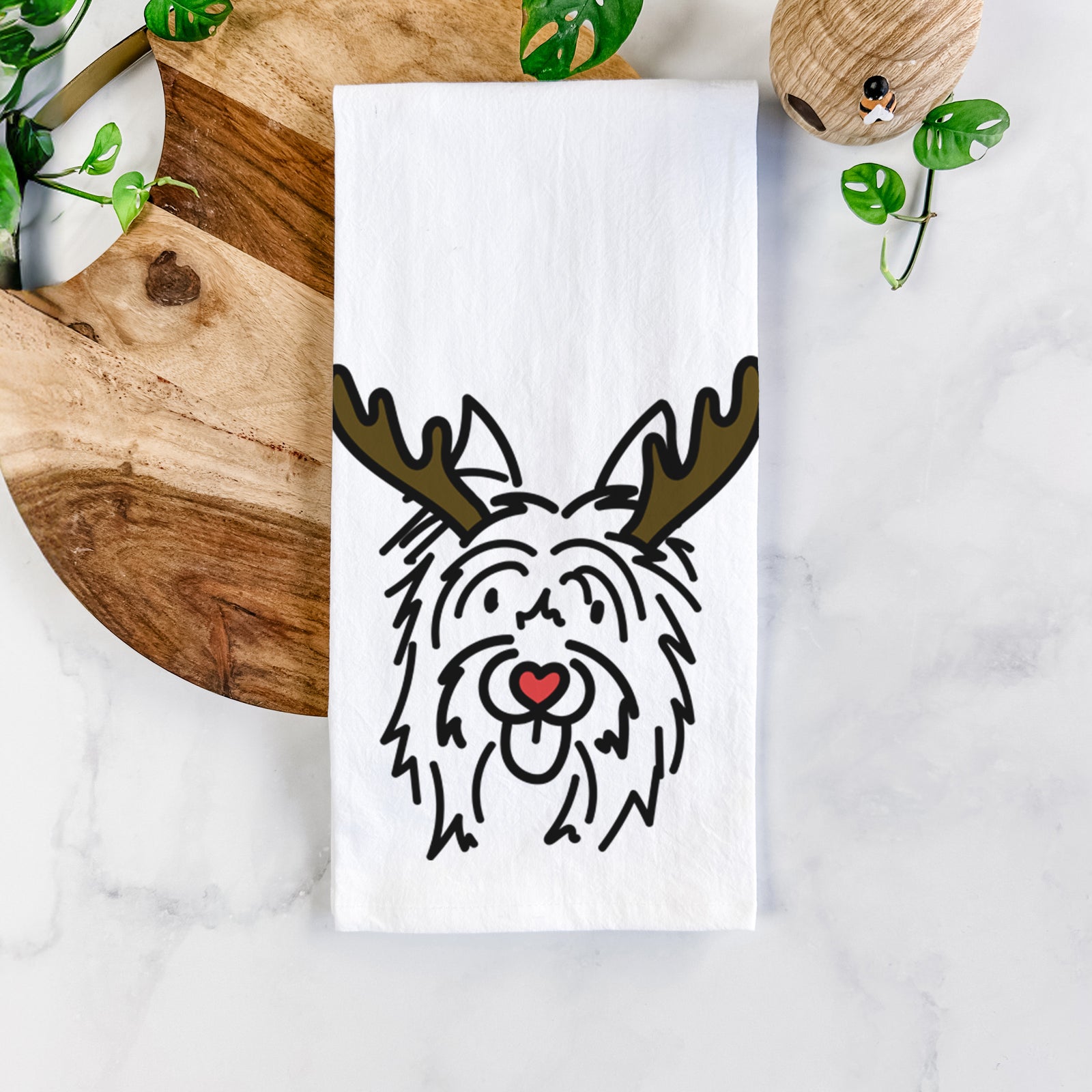 Minimalist line drawing of Monty the Silky Terrier with reindeer antlers and a red nose on a tea towel