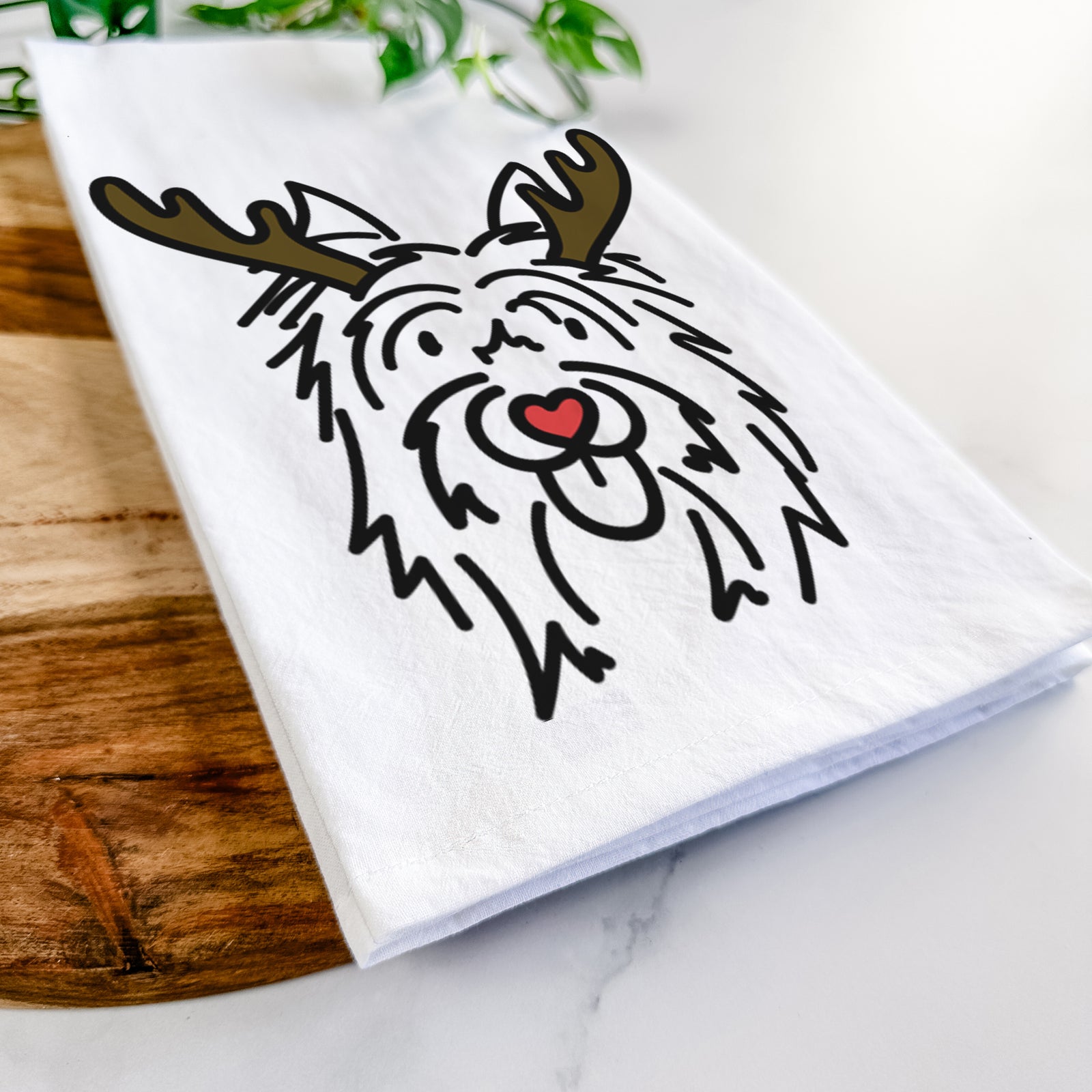Minimalist line drawing of Monty the Silky Terrier with reindeer antlers and a red nose on a tea towel