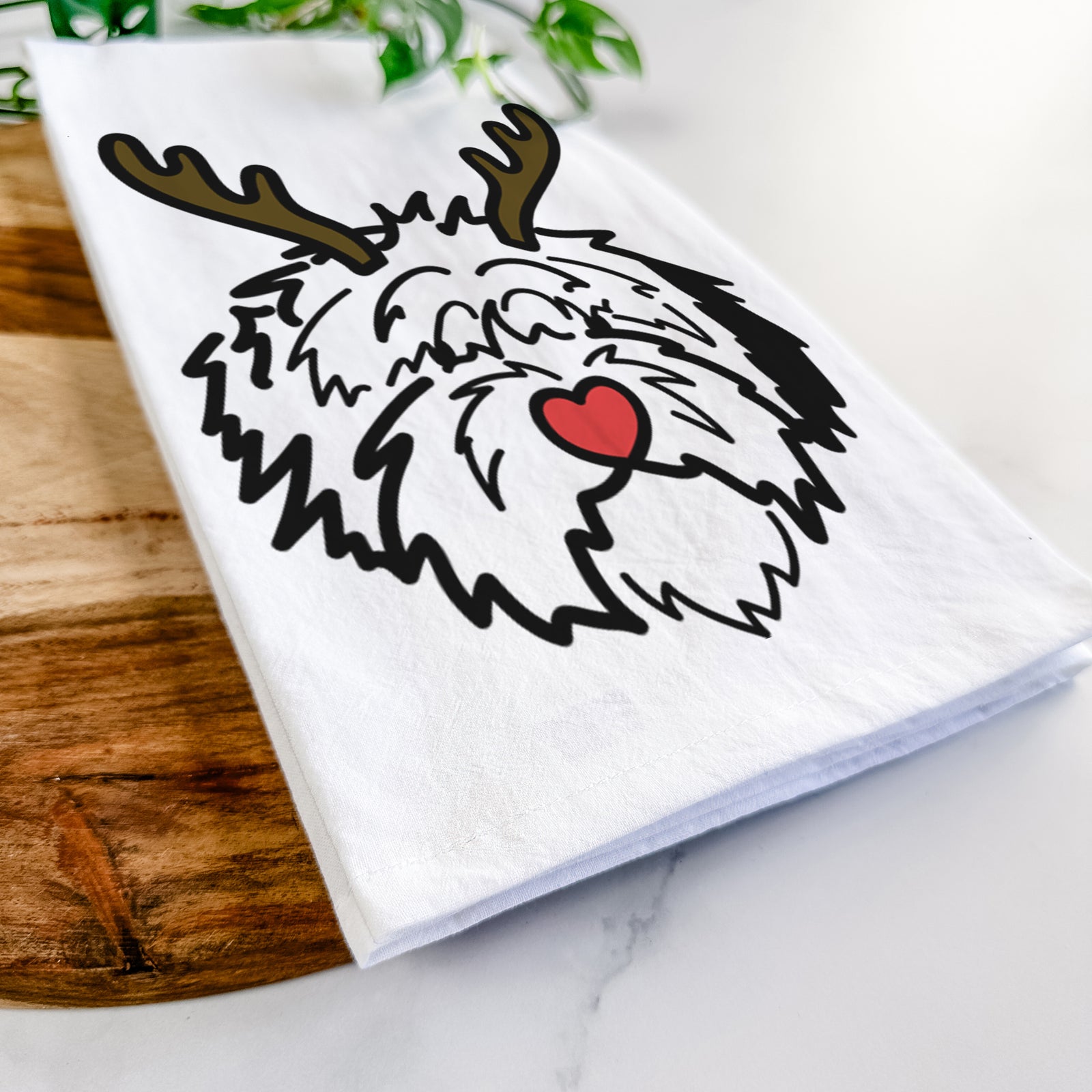 Minimalist line drawing of Penny the Old English Sheepdog with reindeer antlers and a red nose on a tea towel