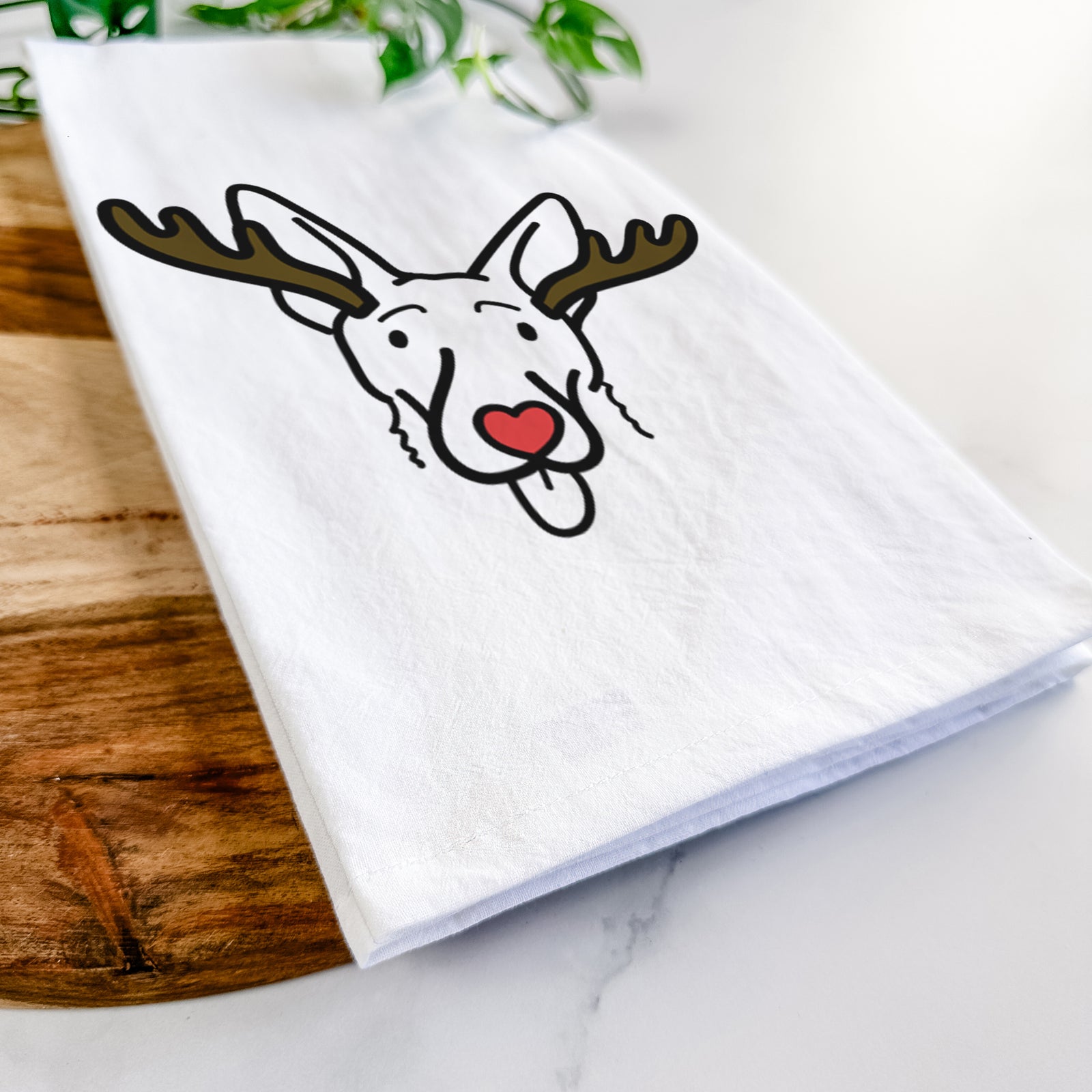 Minimalist line drawing of Rosie the Shepherd Mix with reindeer antlers and a red nose on a tea towel