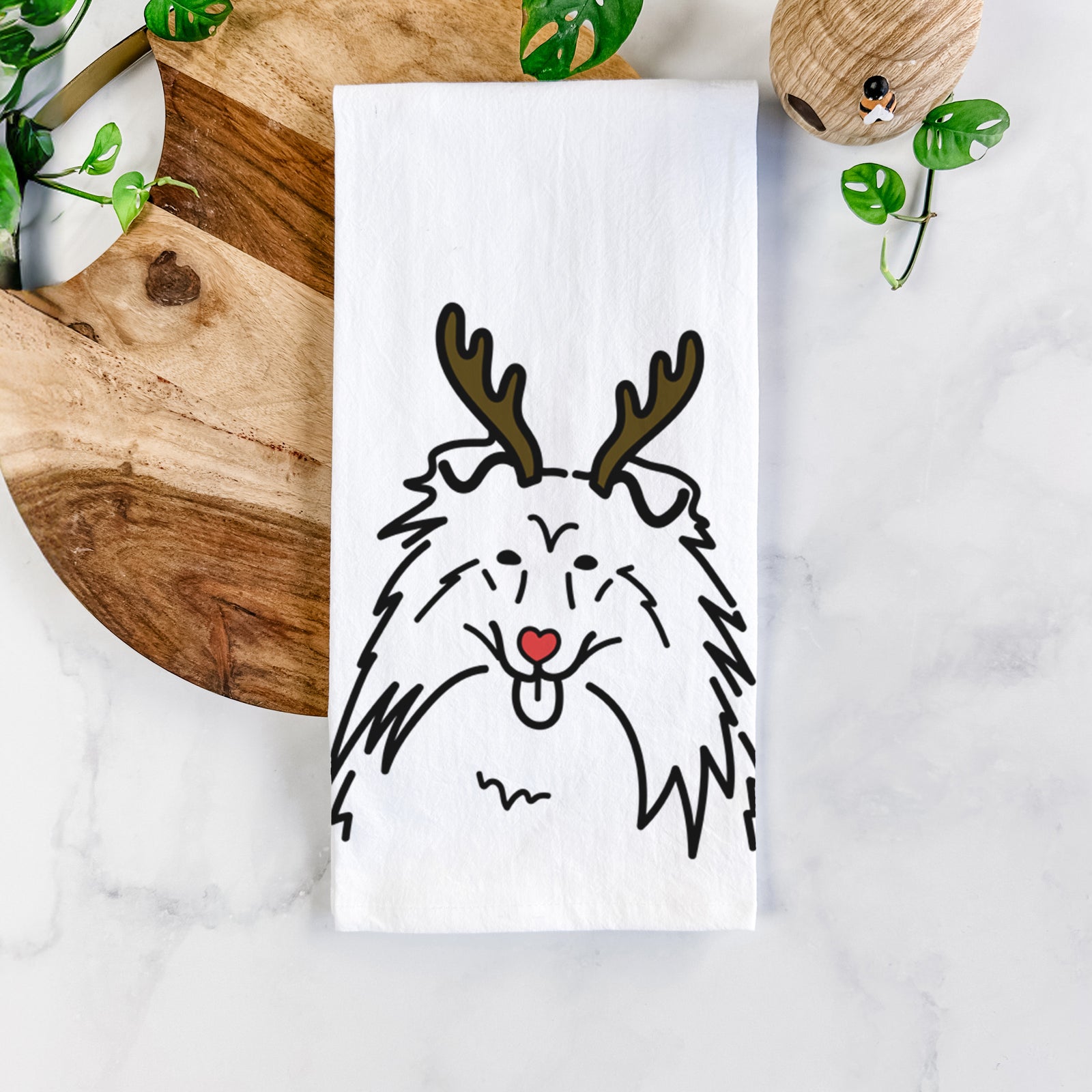 Minimalist line drawing of a Rough Collie with reindeer antlers and a red nose on a tea towel