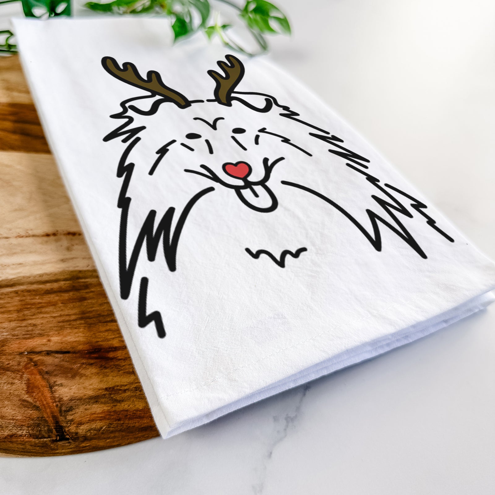 Minimalist line drawing of a Rough Collie with reindeer antlers and a red nose on a tea towel