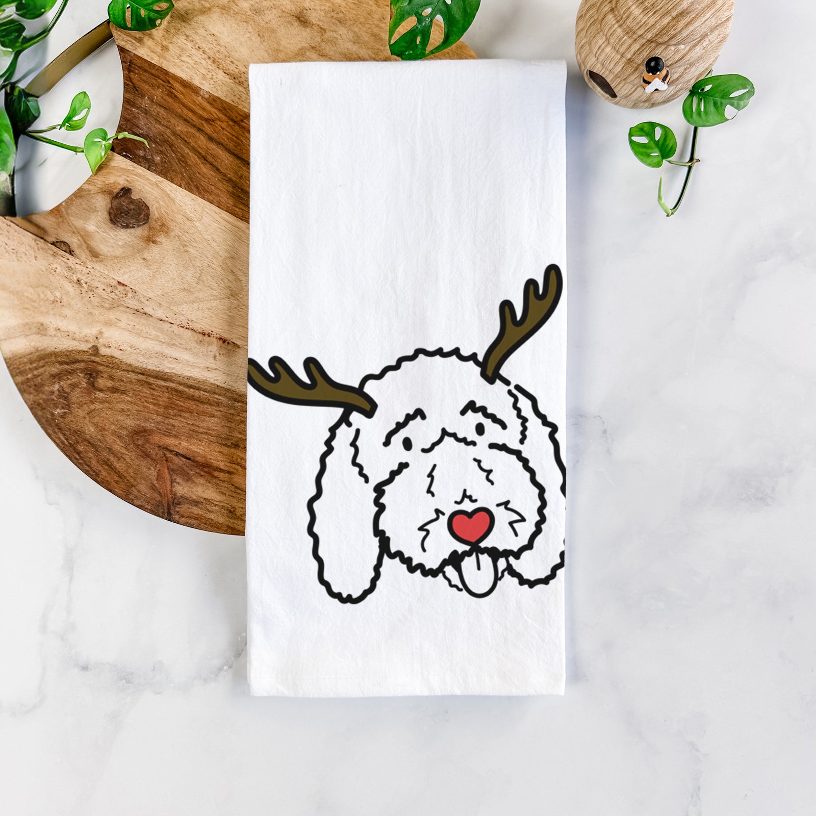 Minimalist line drawing of Ruby the Bernedoodle with reindeer antlers and a red nose on a tea towel