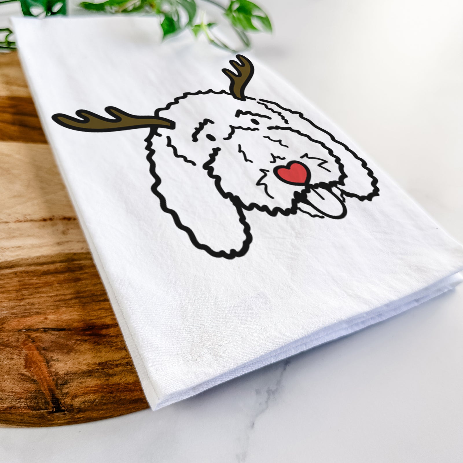 Minimalist line drawing of Ruby the Bernedoodle with reindeer antlers and a red nose on a tea towel