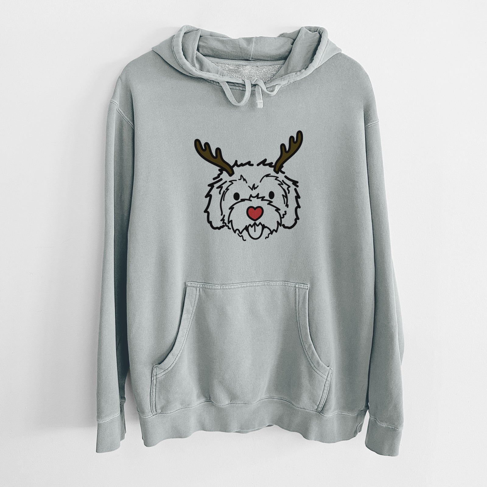 Minimalist line drawing of Sprinkles the Cockapoo with reindeer antlers and a red nose on a Sage Unisex pigment dyed hoodie