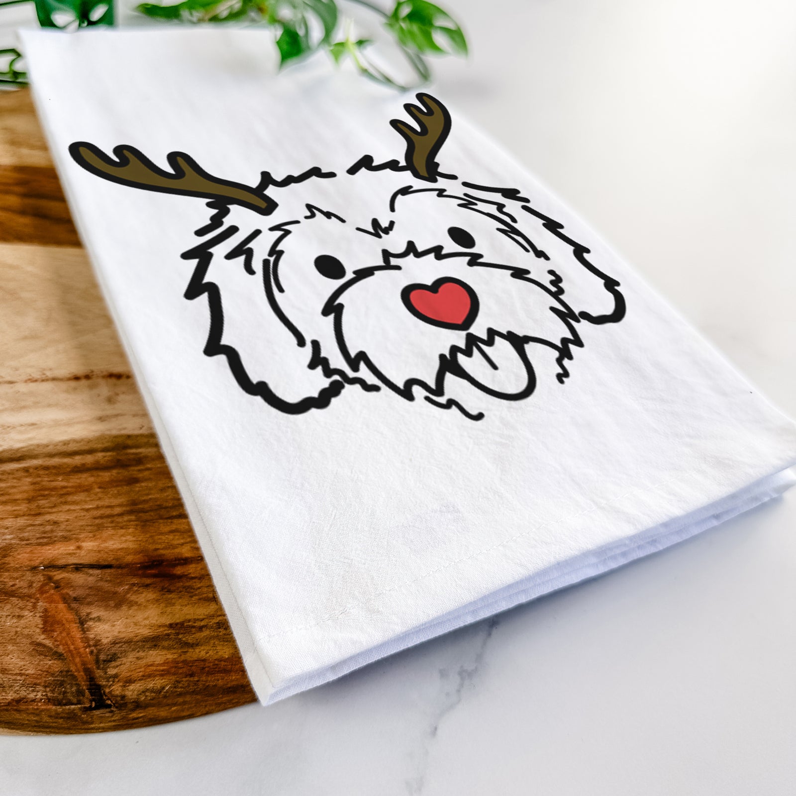 Minimalist line drawing of Sprinkles the Cockapoo with reindeer antlers and a red nose on a tea towel