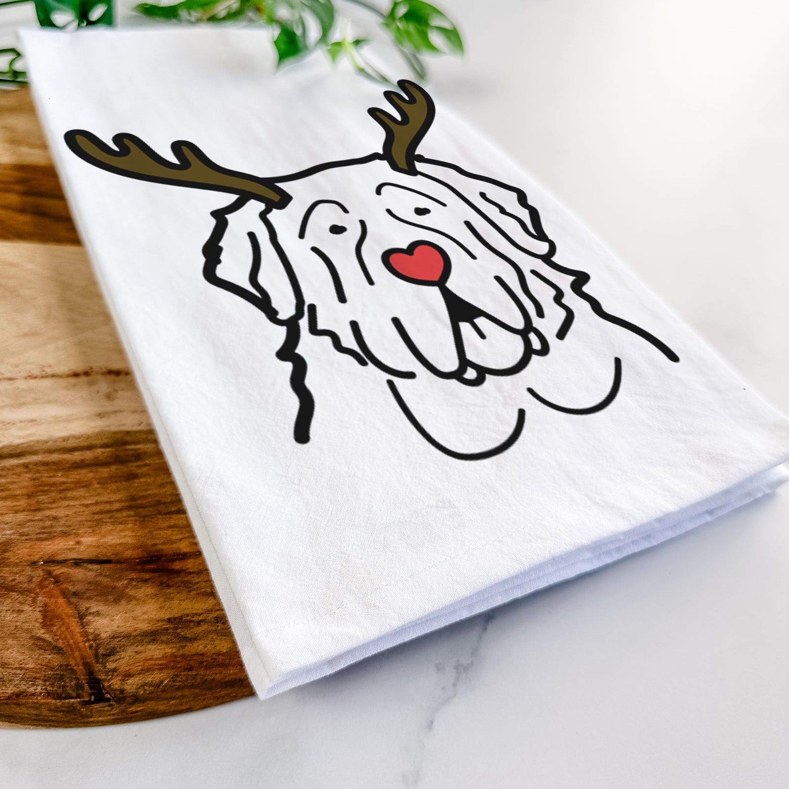 Minimalist line drawing of a Saint Bernard with reindeer antlers and a red nose on a tea towel