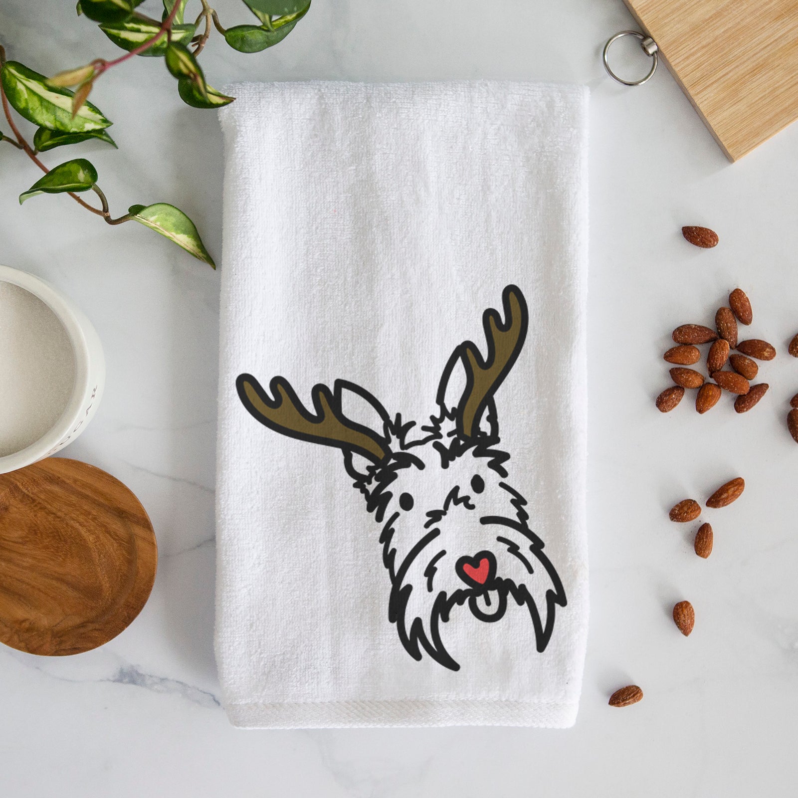 Minimalist line drawing of Thistle the Scottish Terrier with reindeer antlers and a red nose on a decorative hand towel