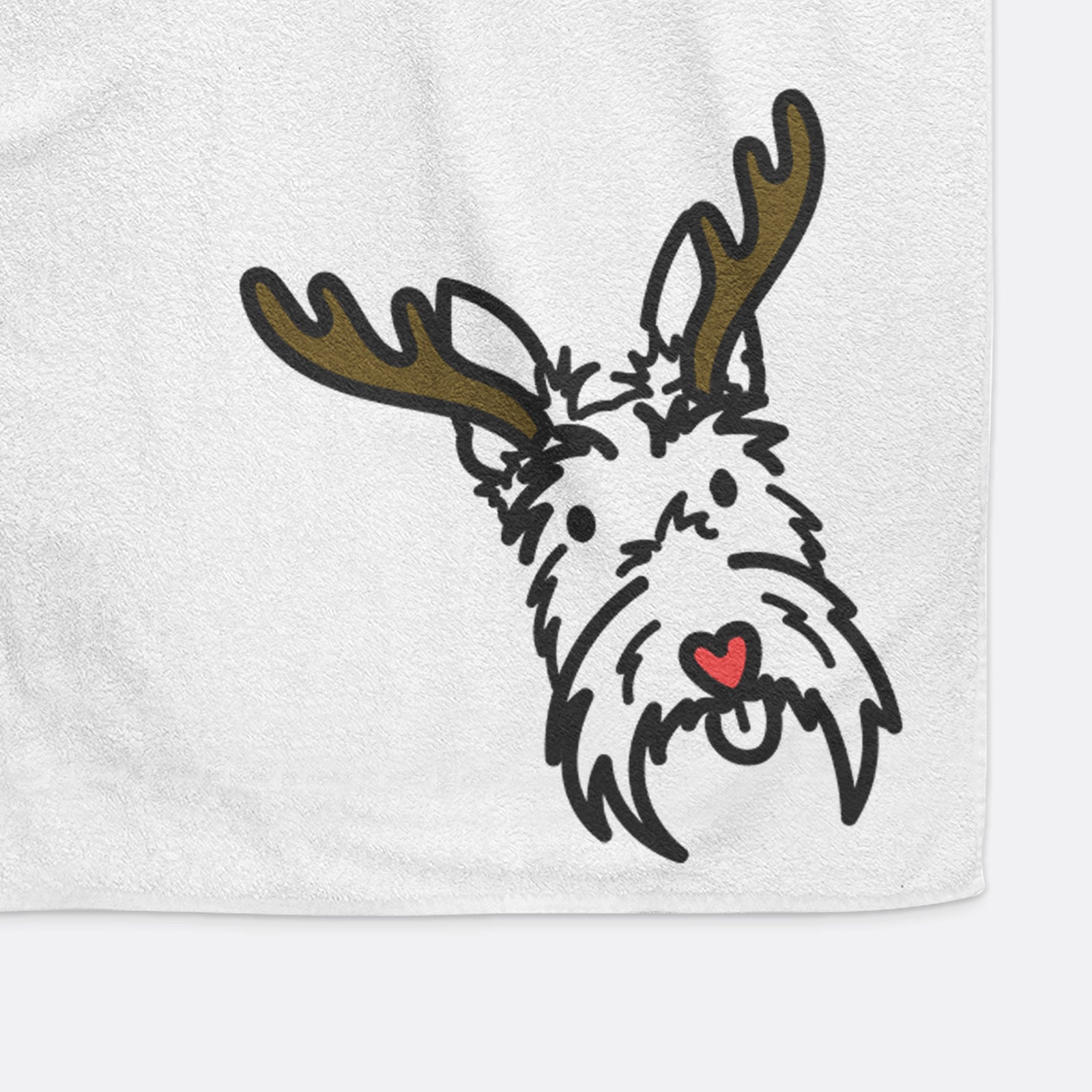 Minimalist line drawing of Thistle the Scottish Terrier with reindeer antlers and a red nose on a decorative hand towel