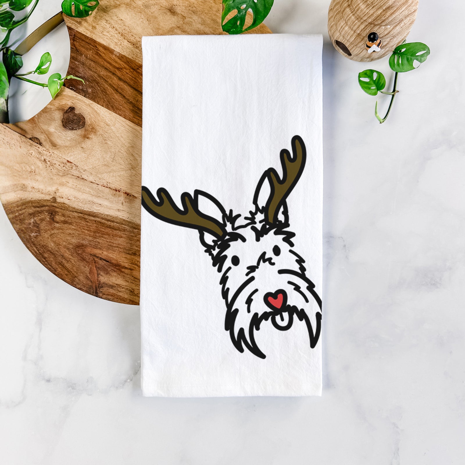 Minimalist line drawing of Thistle the Scottish Terrier with reindeer antlers and a red nose on a tea towel