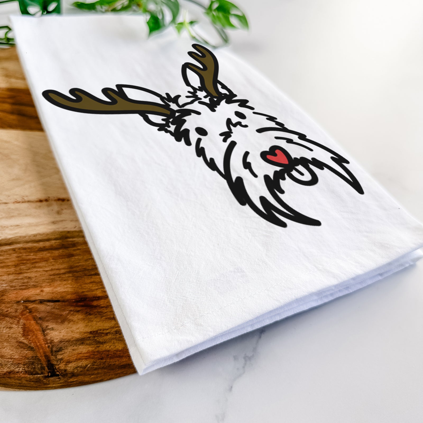 Minimalist line drawing of Thistle the Scottish Terrier with reindeer antlers and a red nose on a tea towel