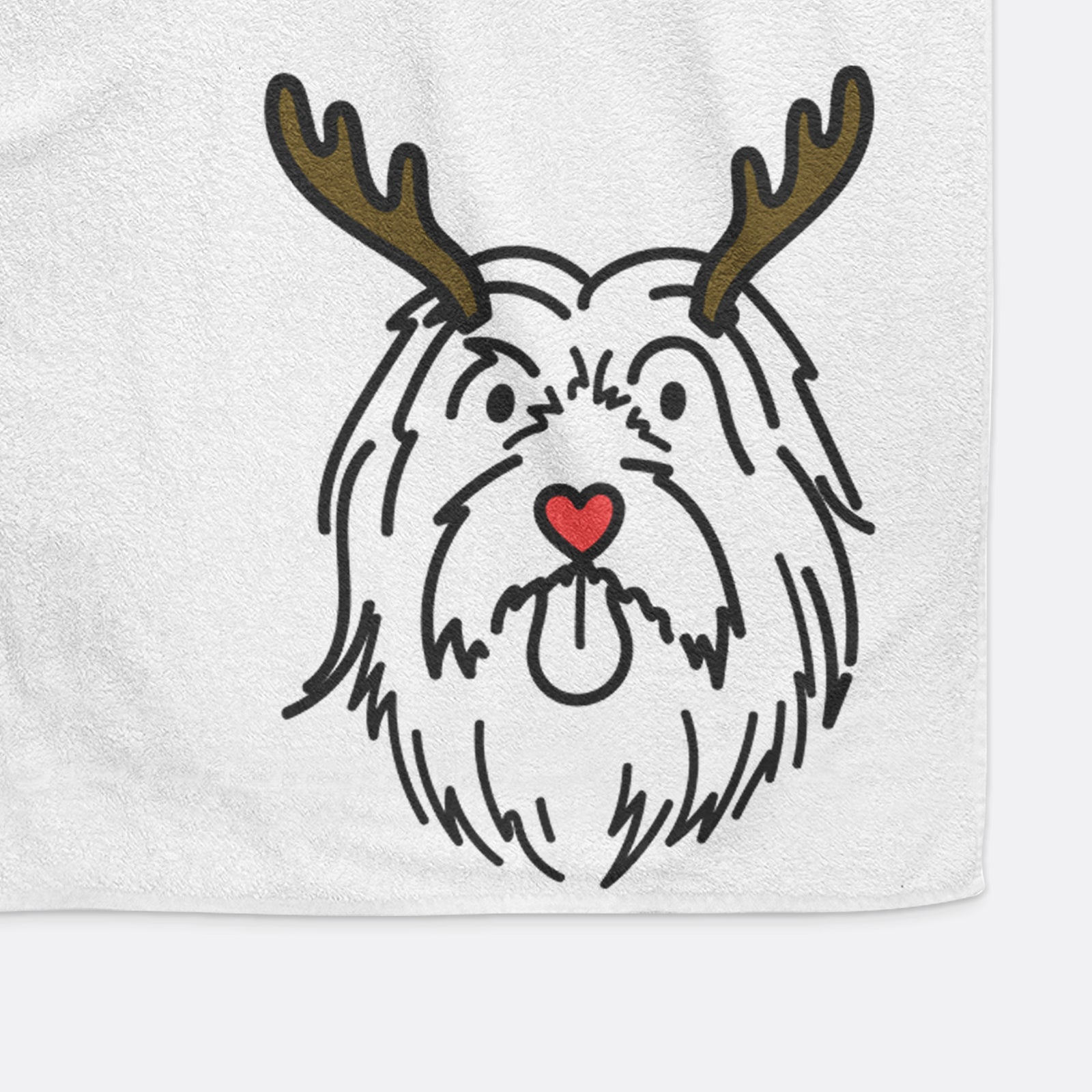 Minimalist line drawing of Tucker the Bearded Collie with reindeer antlers and a red nose on a decorative hand towel