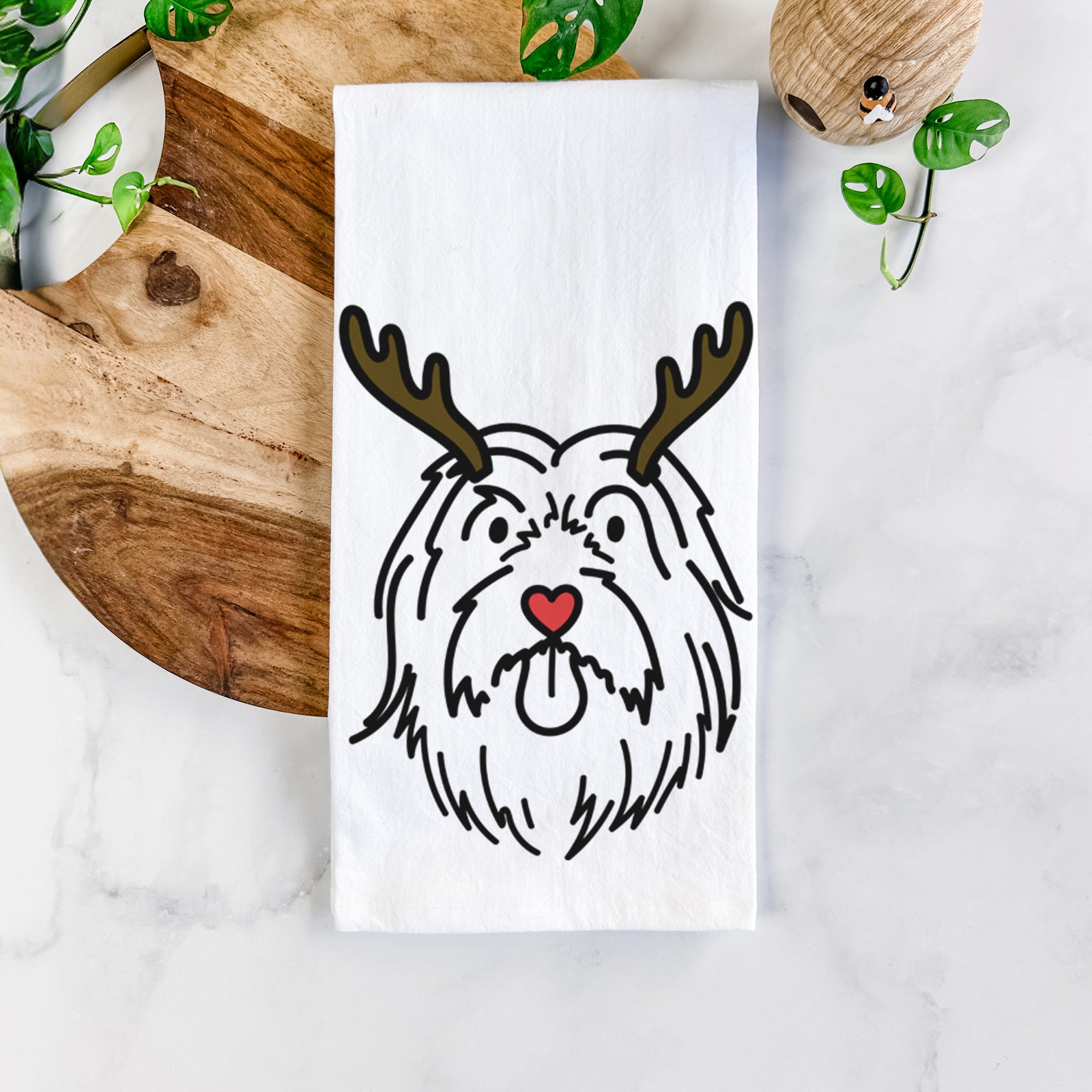 Minimalist line drawing of Tucker the Bearded Collie with reindeer antlers and a red nose on a tea towel